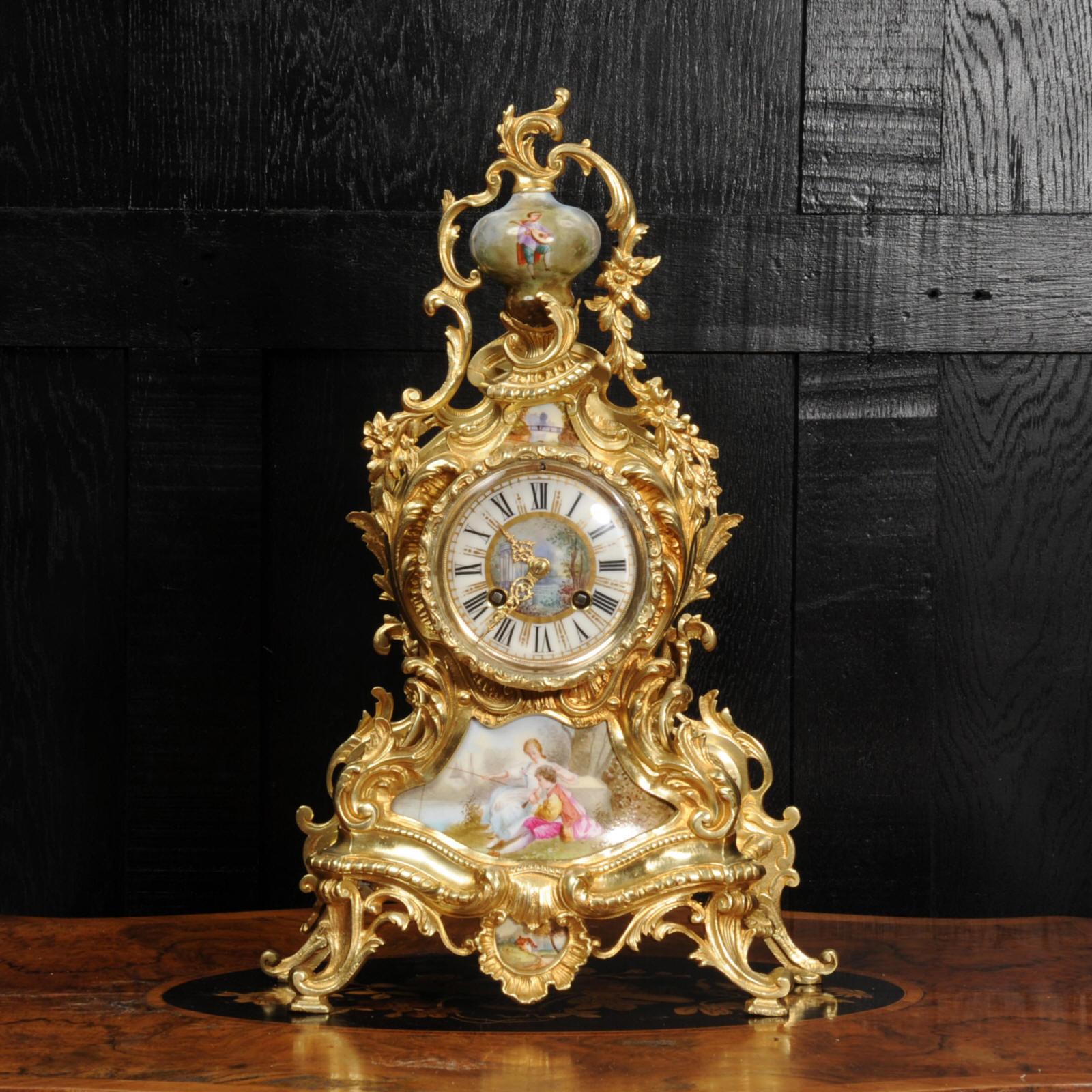 A stunning antique French Rococo clock, circa 1880. Beautifully made in finely gilded bronze and mounted with exquisite Sèvres style porcelain. The case is of a waisted design with profuse, twirling acanthus decoration and scrolls. Porcelain has a