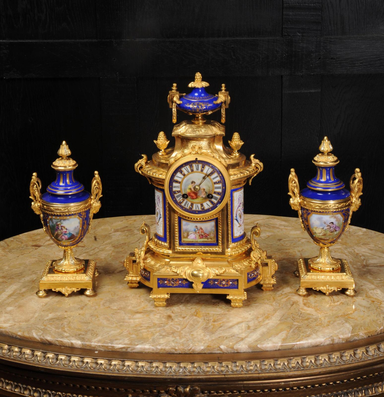 A beautiful antique French ormolu (finely gilded bronze) and Sevres type porcelain clock set, circa 1870. It is by the famous clockmaker Japy Freres and was retailed in London by Richard et Cie. It features a stunning set of porcelain panels with a