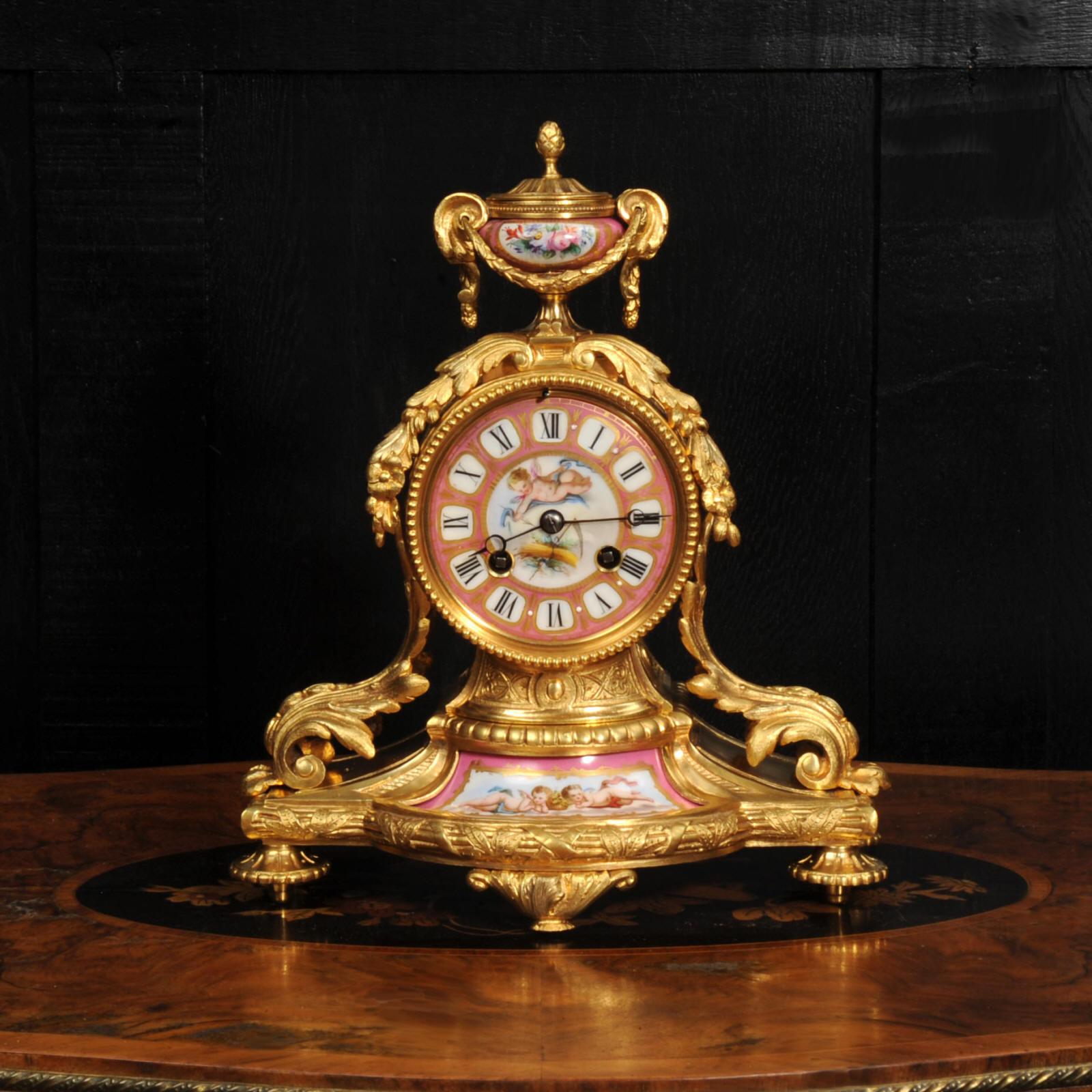 A stunning original antique French boudoir clock by the renown maker Japy Frères. It is made of exquisite ormolu (finely gilded bronze) mounted with delicately painted Sèvres style porcelain. The Porcelain is decorated with a pompadour rose pink