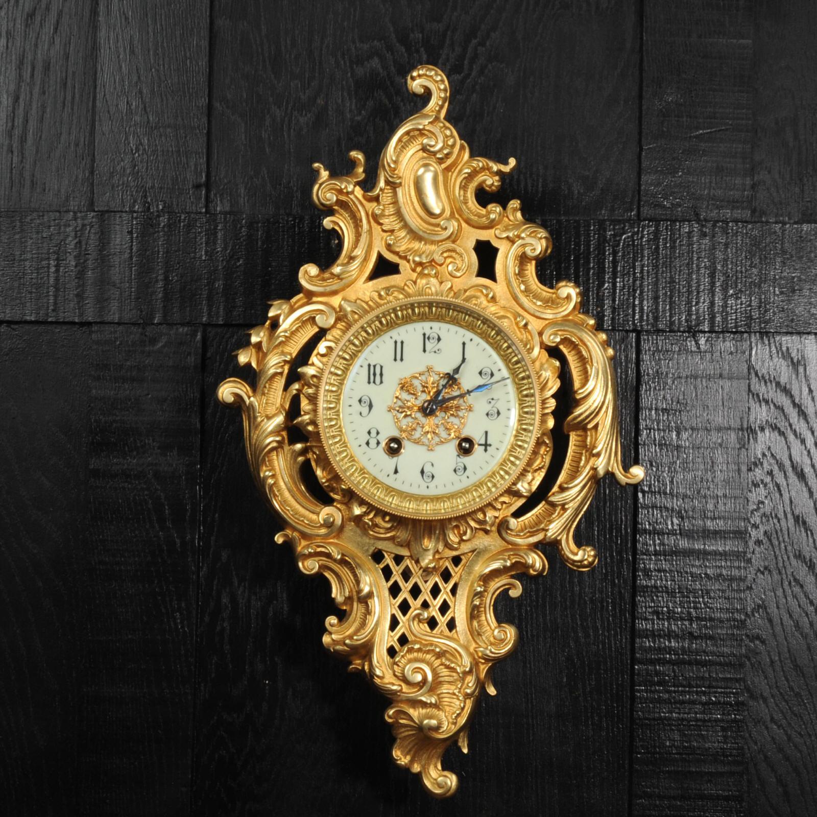 A stunning original antique French wall clock by the famous maker Japy Frères. It is beautifully designed in the Rococo style with profuse asymmetric 'C' scrolls, acanthus leaves and a curved panel of trellis work that allows a glimpse of the