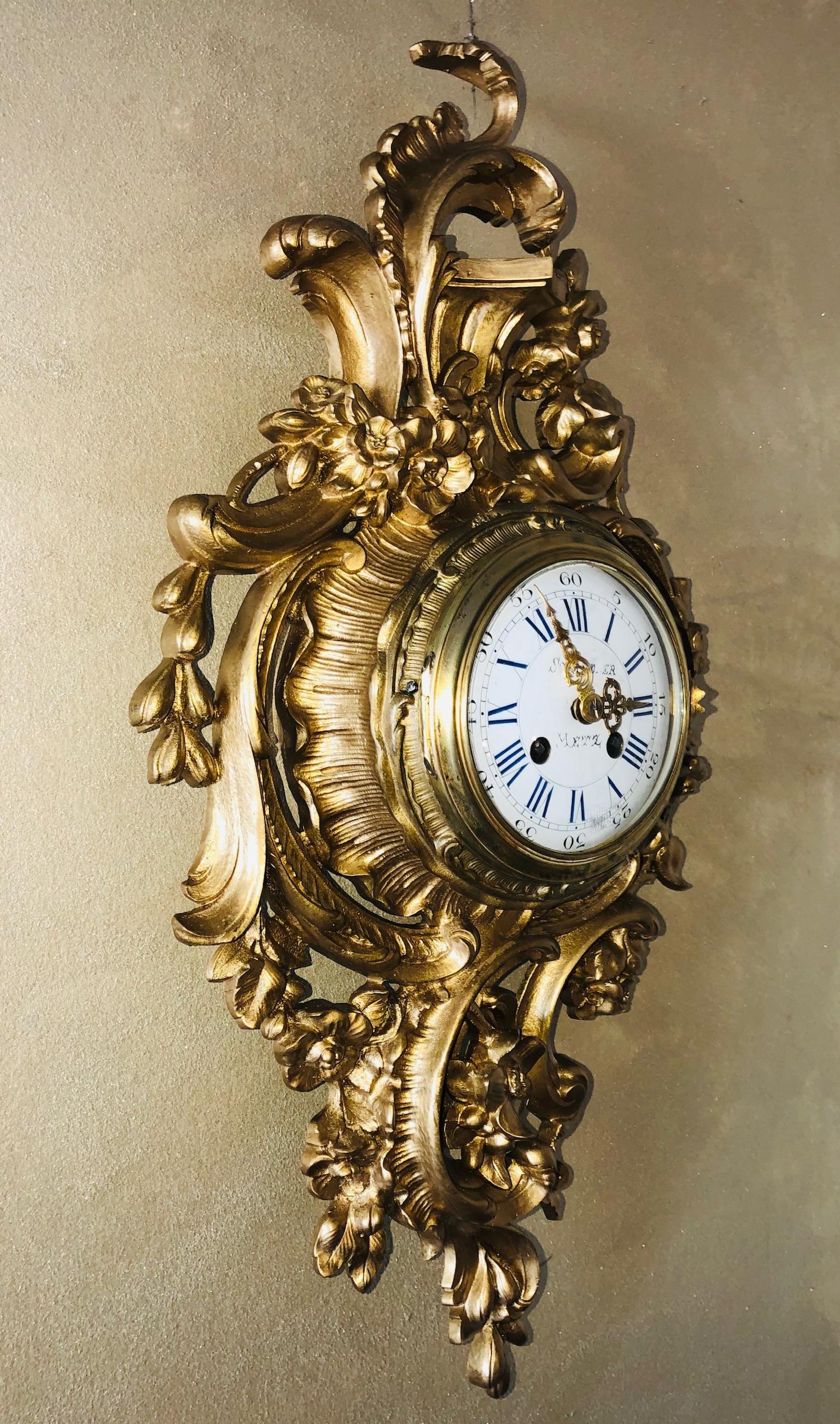This is a mid-19th century cartel, or wall clock, is in the style of Louis XV with a lovely feather and floral motif as well as the traditional swirls and curves of the Rococo style. The movement was made by the Japy Bros. Co. of Paris France, circa