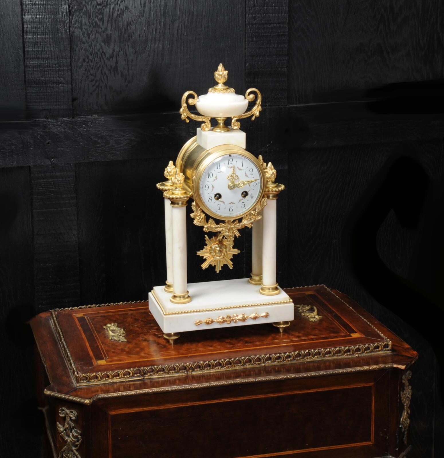 A beautiful original antique French portico clock by Japy Freres, circa 1880. It is made of white marble mounted with ormolu (finely gilded bronze). The movement is held aloft on two marble pillars with the ormolu pendulum swinging gently below.