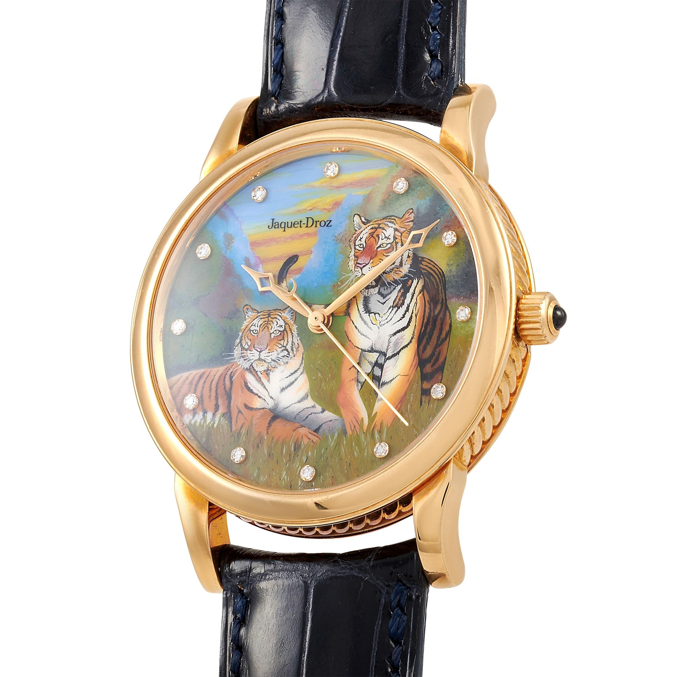 The Jaquet-Droz Tiger watch, reference number 2225, comes with a 36 mm 18K yellow gold case that boasts transparent back. The case is presented on a blue leather strap fitted with a tang buckle. This model is powered by a self-winding movement that
