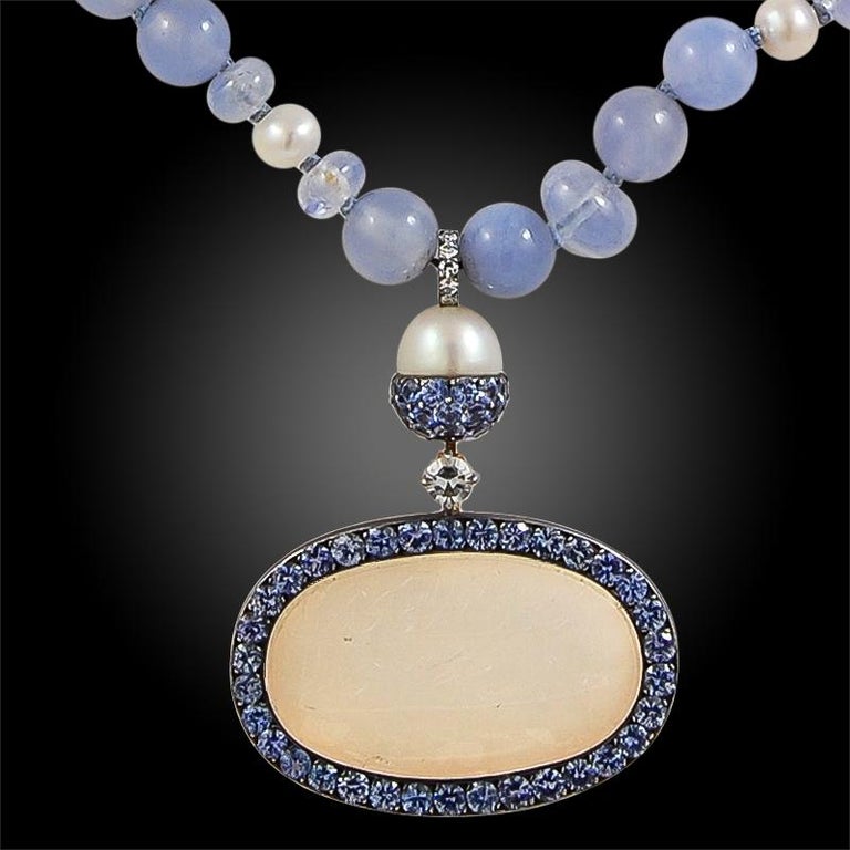 A stylish JAR Paris necklace that dates back to the 1980s, suspending an engraved chalcedony intaglio featuring carved Arabic script ‘Ali Quatrain’ for use as talismanic amulets. The necklace is set with an opulence of brilliant sapphires, diamonds,
