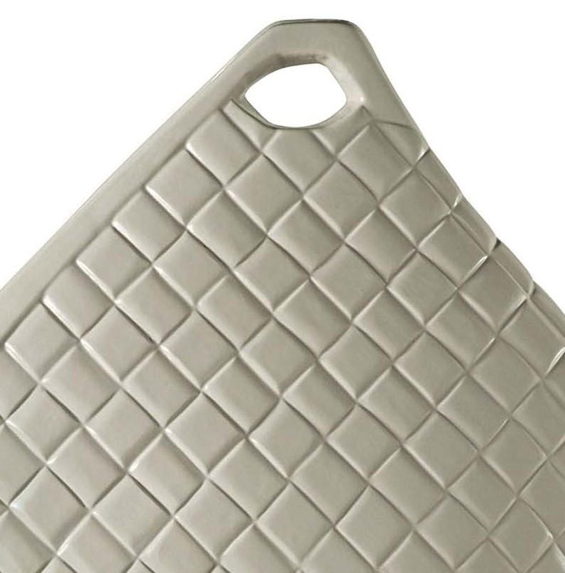 Delicate forms and sleek lines characterize this exceptional ceramic vase from the Jar collection by Missoni Home. Shaped like a flower basket with an extended triangular handle, this vase has a quilted surface and a thick exterior edge glazed
