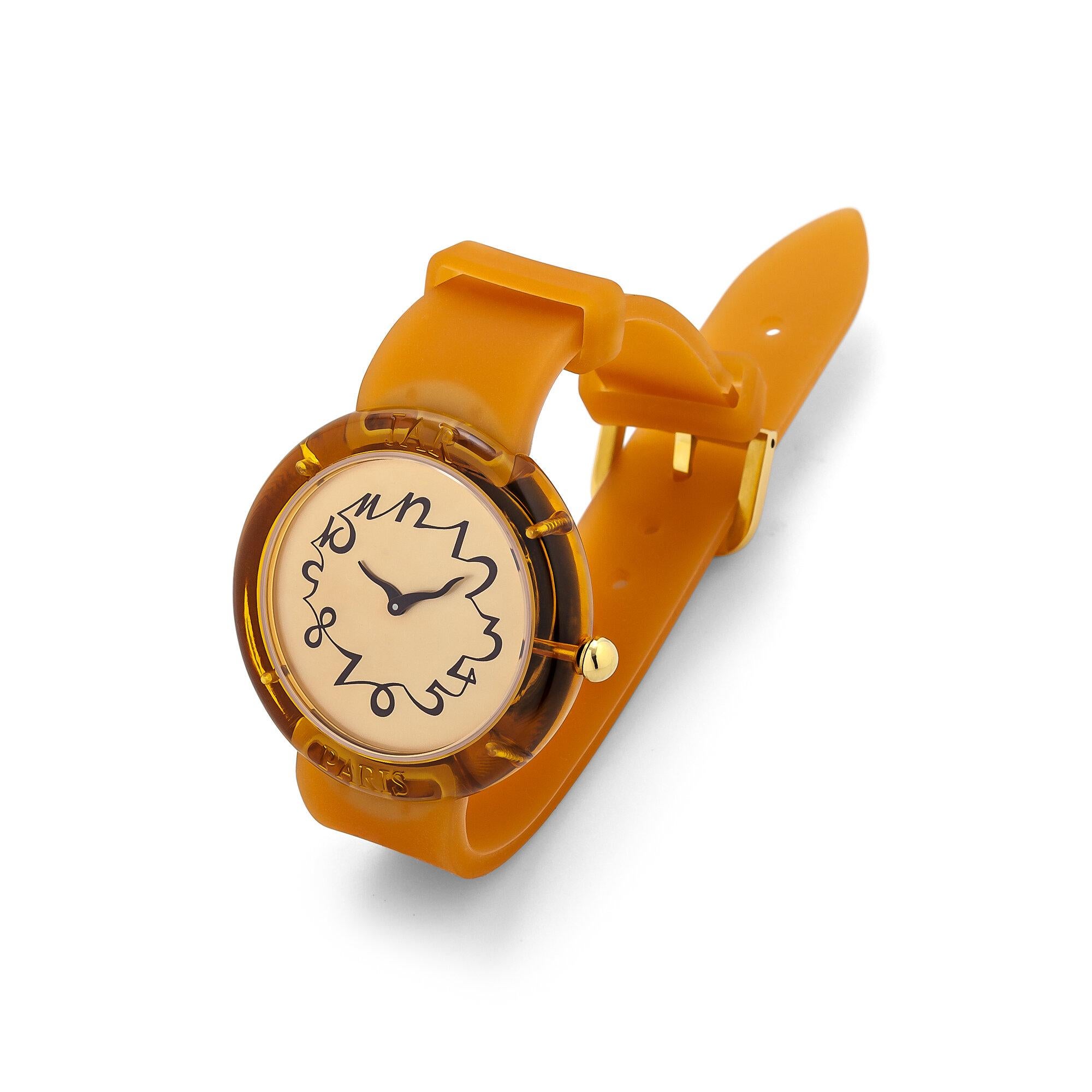 This JAR designed and collectible vintage watch from the Metropolitan Museum of Art collection is wearable fine art.  With a orange silicone watch strap, a champagne colored face, and a cognac hued perspex bezel, this watch was masterfully designed.