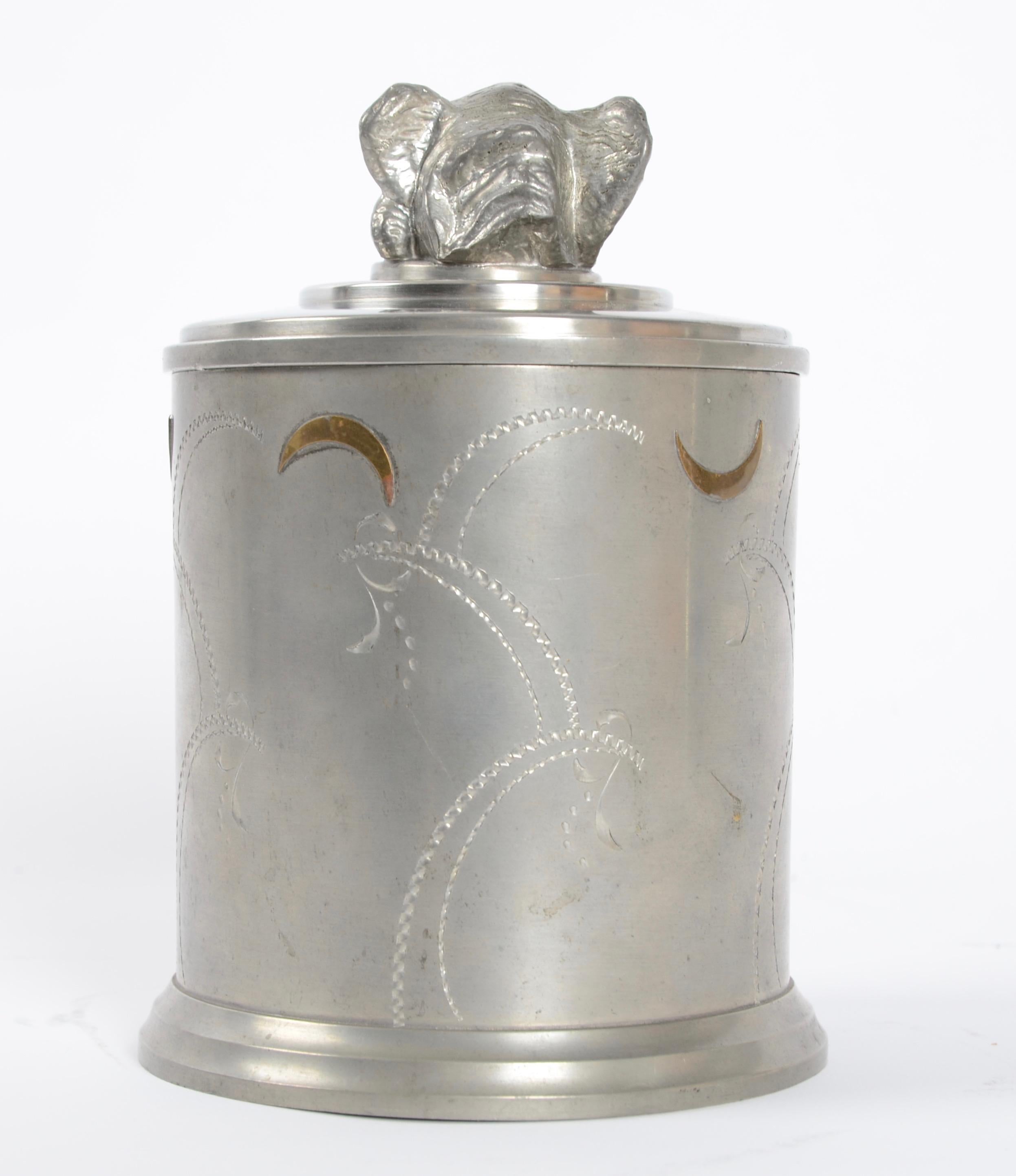 Jar in pewter and brass, lid with decor in shape of elephants head. Marked: Prima Svenskt Tenn, Handarbete/handmade, Stockholm D8 (1930).