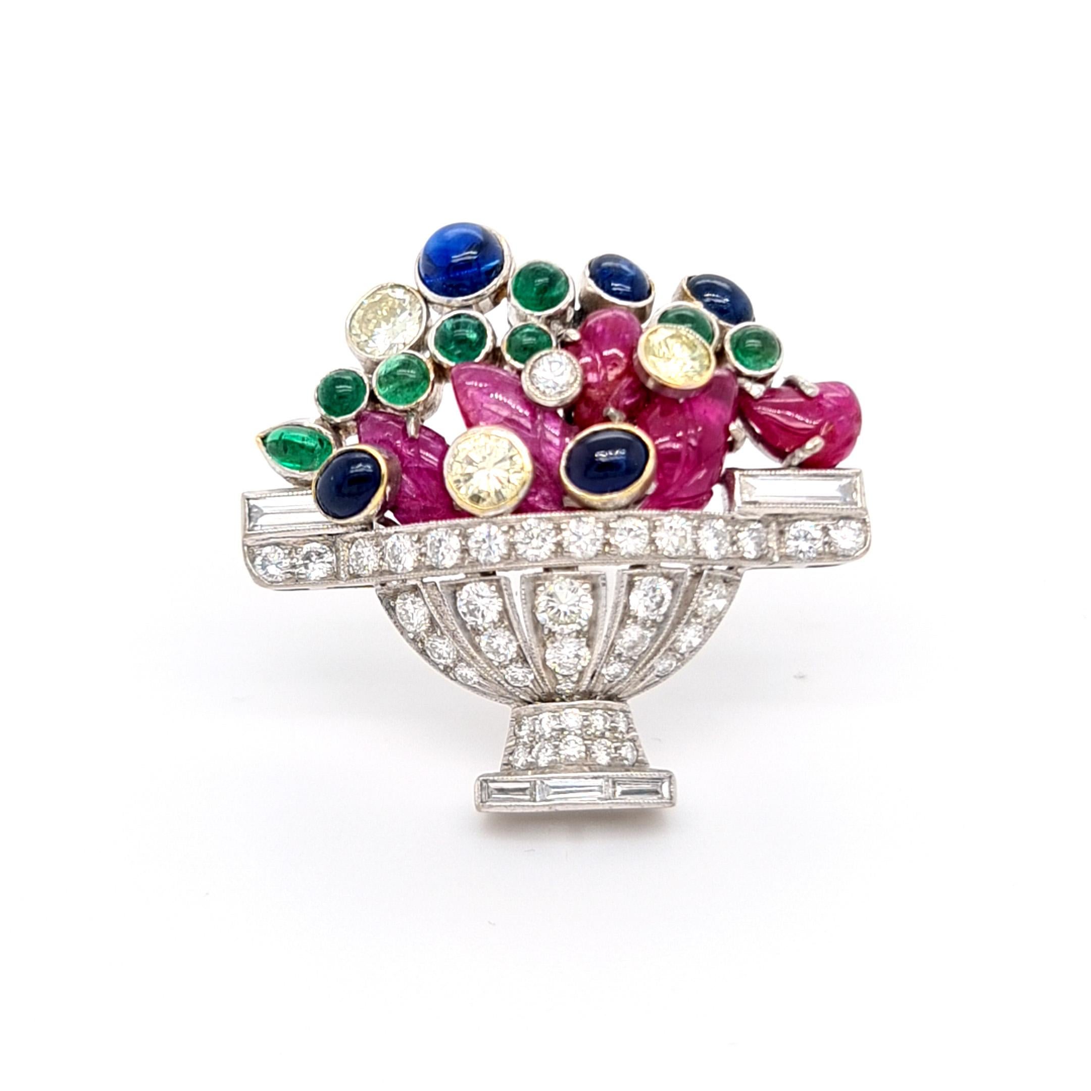 A Jardiniére brooch, mounted in platinum, with a diamond bowl set with round brilliant and baguette-cut diamonds, with carved rubies and cabochon-cut sapphires and emeralds depicting the flowers. Circa 1960.