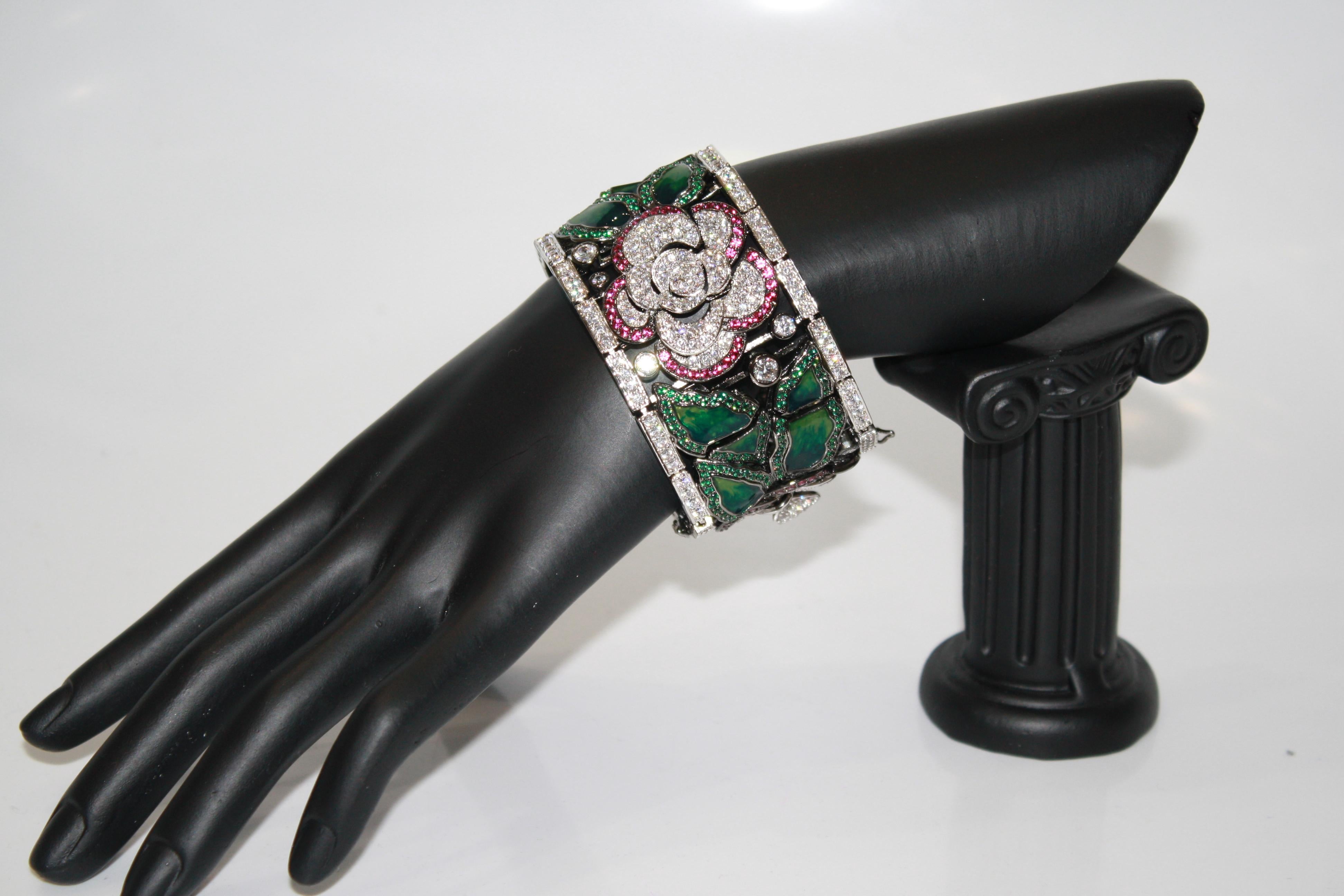 In an Art Deco style this bracelet is made of articulated rectangular pieces in dark rhodium with inlaid enamel flower motifs and colored zirconium of the finest quality.
