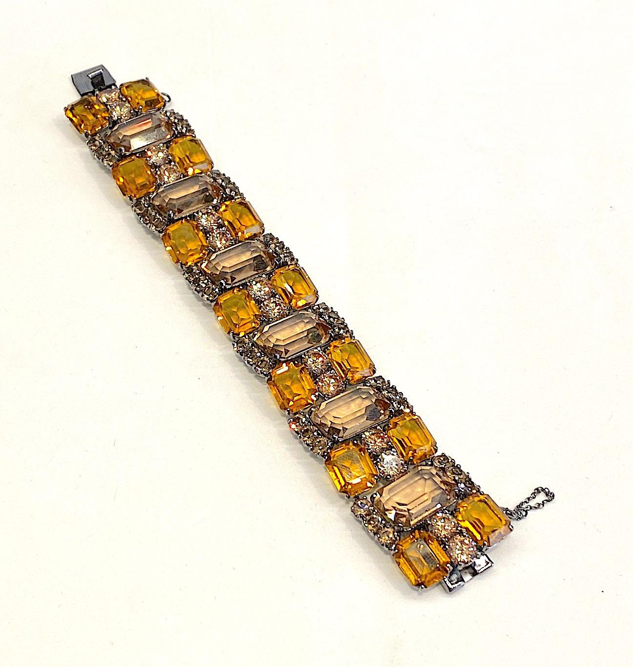 A Jarin Kasi elegant bracelet is sterling silver and set with gold and pale amber color cubic zirconia. The sterling silver is patinated with a gun metal charcoal grey finish. All of the stones are clear and open back. The bracelet is made up of 6