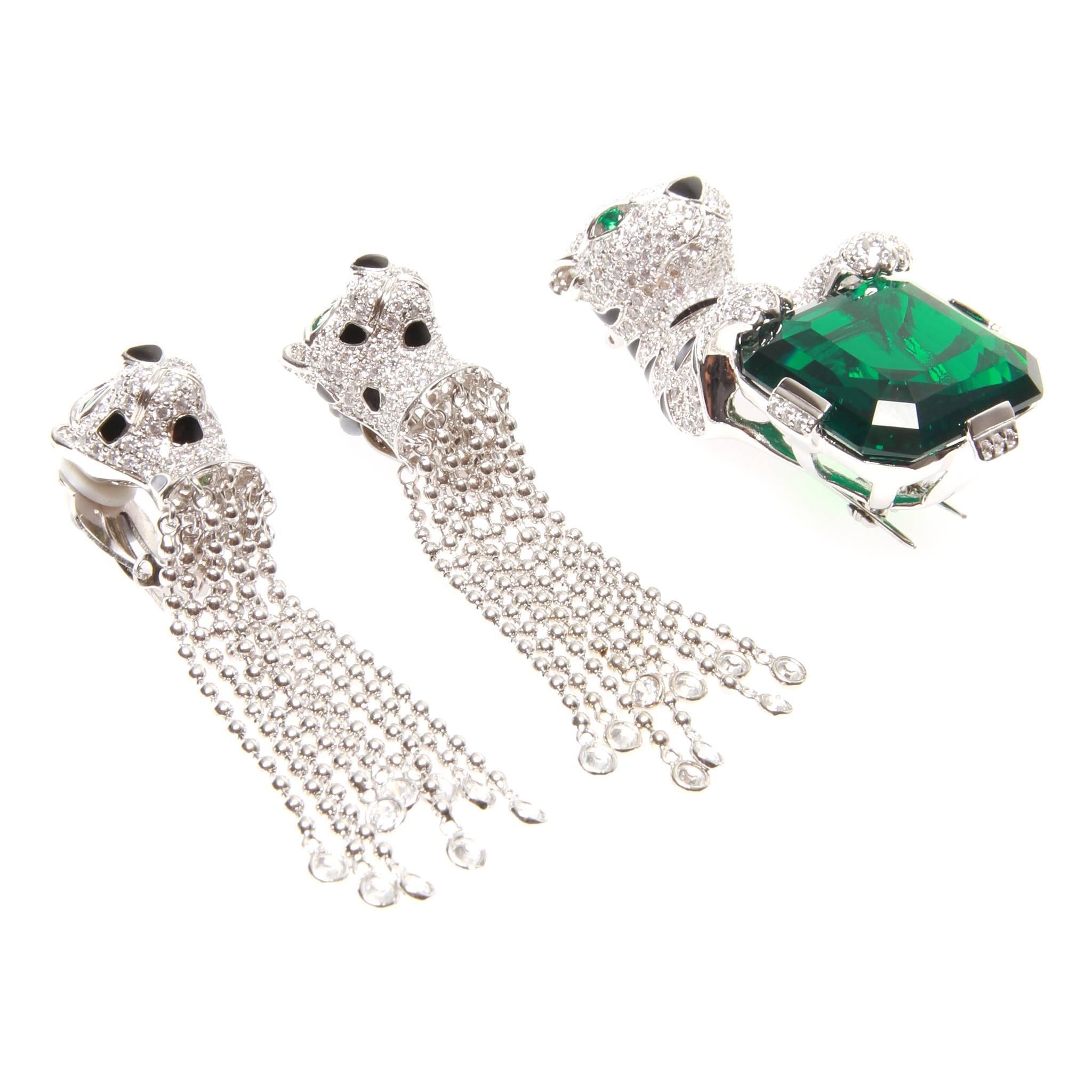 A stunning Jarin sterling silver leopard earring and brooch jewellery set.

It features a pair of sterling silver Leopard dangle earrings and leopard brooch, embellished with a large and beautiful Green cubic zirconia.

Dress up with a black