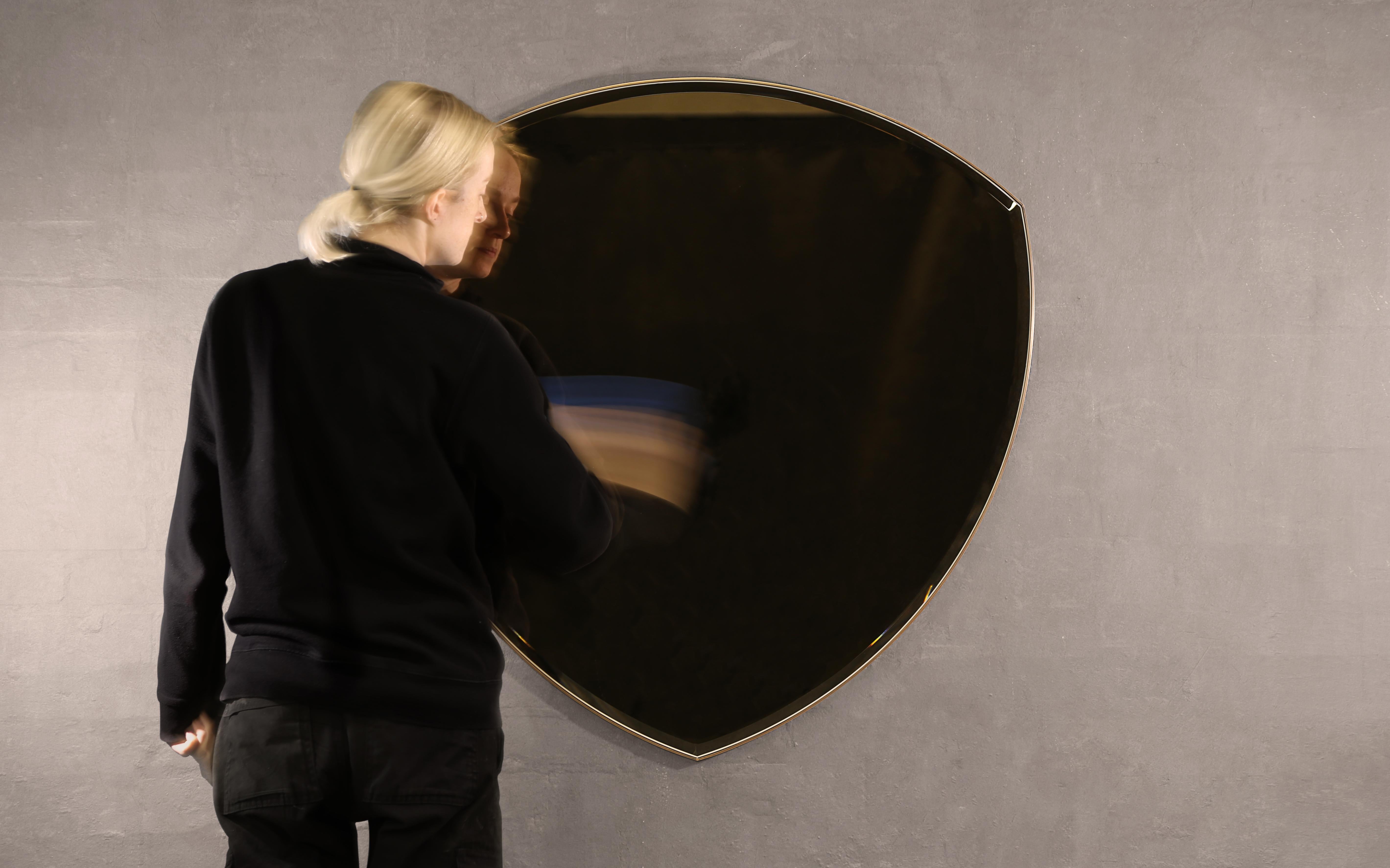 A wall mirror in polished brass and bevelled, bronze tinted glass. Hand crafted in the North to order. 

Supplied with two screw fixing points to rear face. Larger mirrors supplied with batten fixing.

Measures: 72.5cm W x 74cm H x 2cm D.
Custom