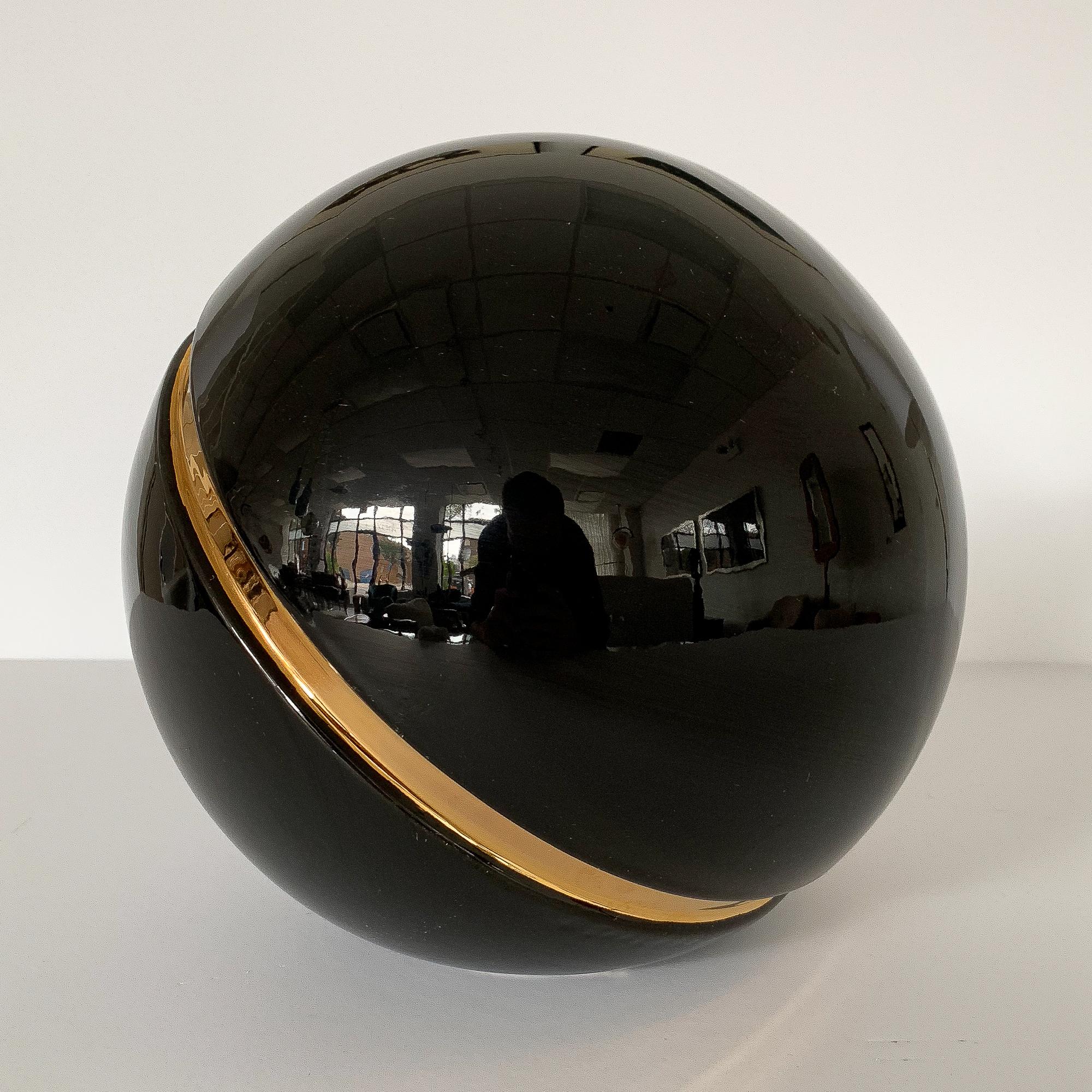 Large Jaru black glazed ceramic sphere with inset groove of metallic gold glaze. The ball measures 11