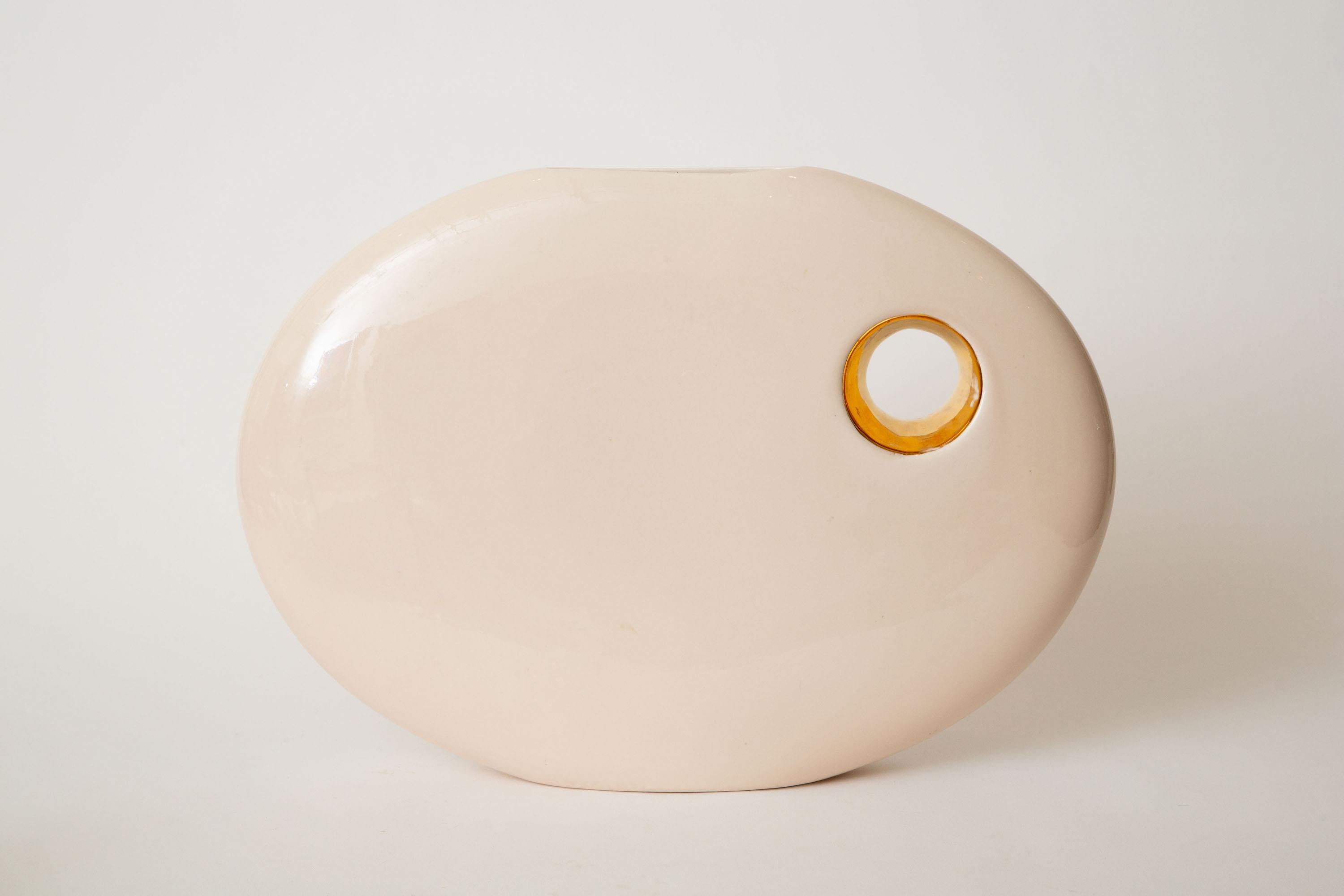 This lovely elongated signed Jaru ceramic sculpture or vessel has a hole on the side. It is 24 carat gold plated. It is cream beige with gold. It has a large presence. This is a unique piece and one that is not on the market readily. Jaru was a
