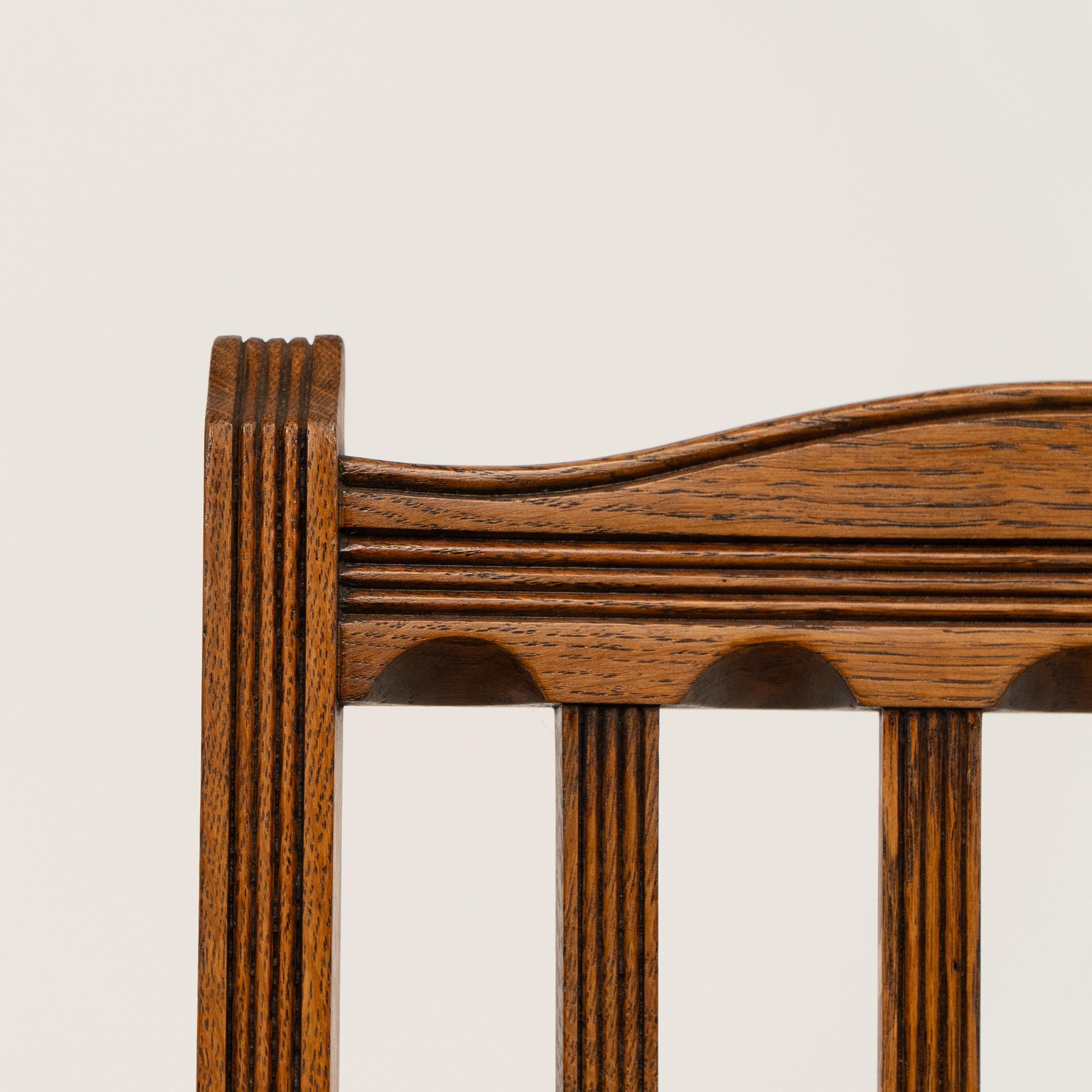 Oak Jas Shoolbred. A set of four Aesthetic Movement lattice back oak dining chairs