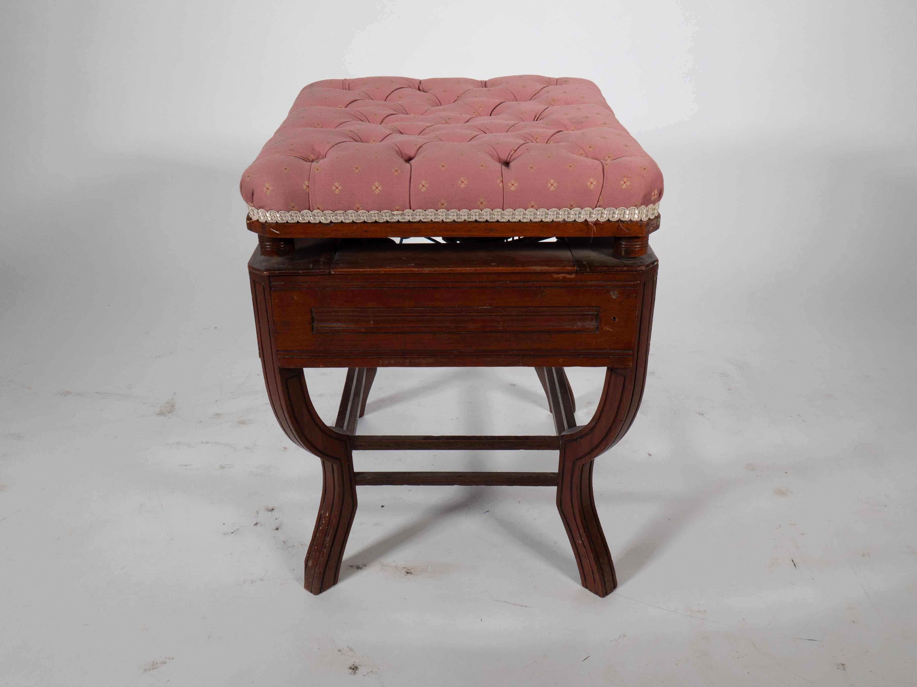 Jas Shoolbred. An Aesthetic Movement adjustable height piano stool with carved florettes and line scribed decoration to the seat and to the shaped legs, united by a double stretcher. This has a BSA motor bike company mechanical height adjusting