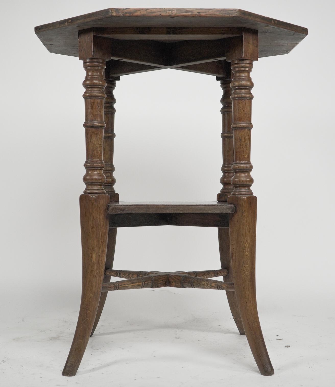 Jas Shoolbred attributed An octagonal oak side table with central shelf, carved circular details to the legs, united by lower cross stretchers.