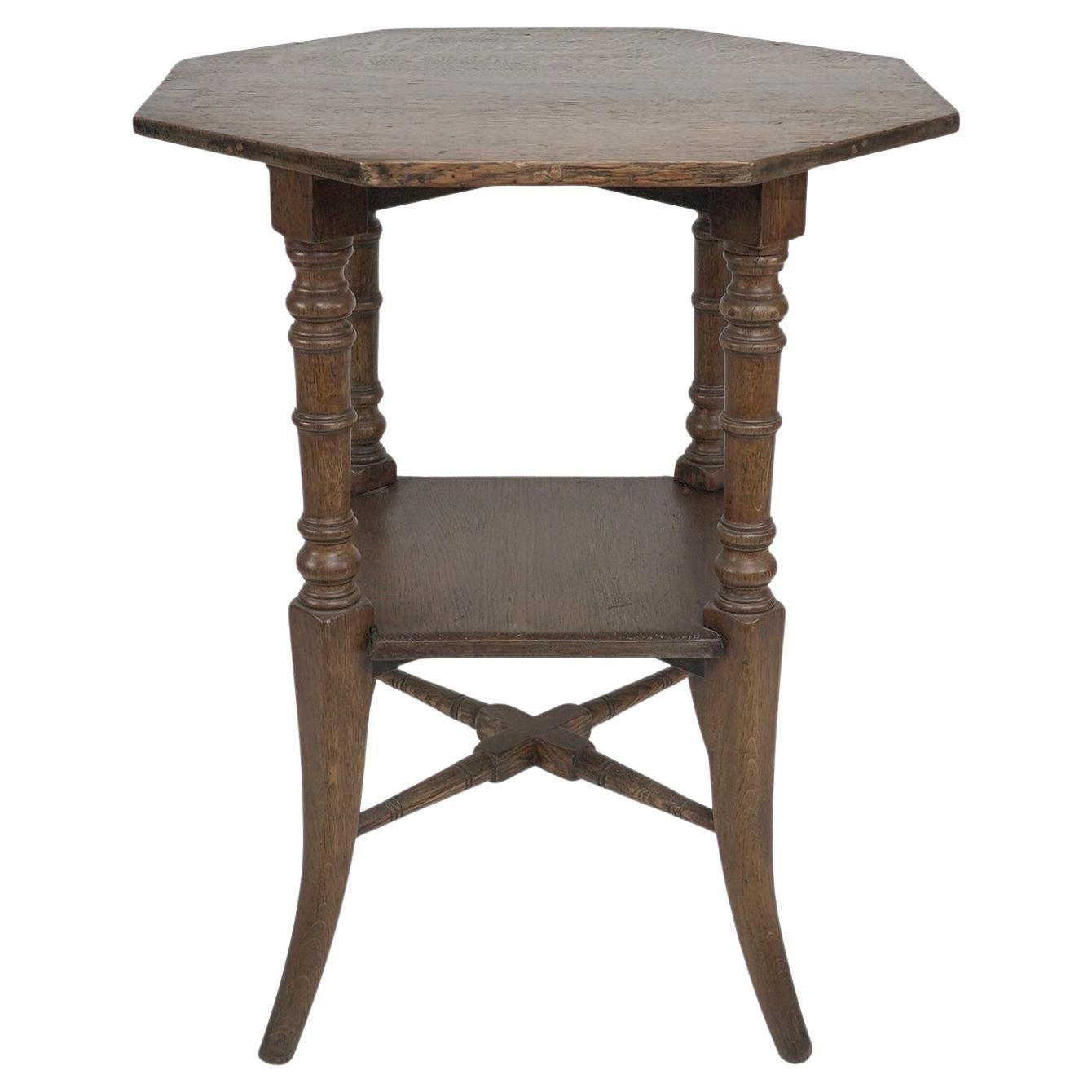Jas Shoolbred and Co (attributed) An octagonal oak side table with central shelf For Sale
