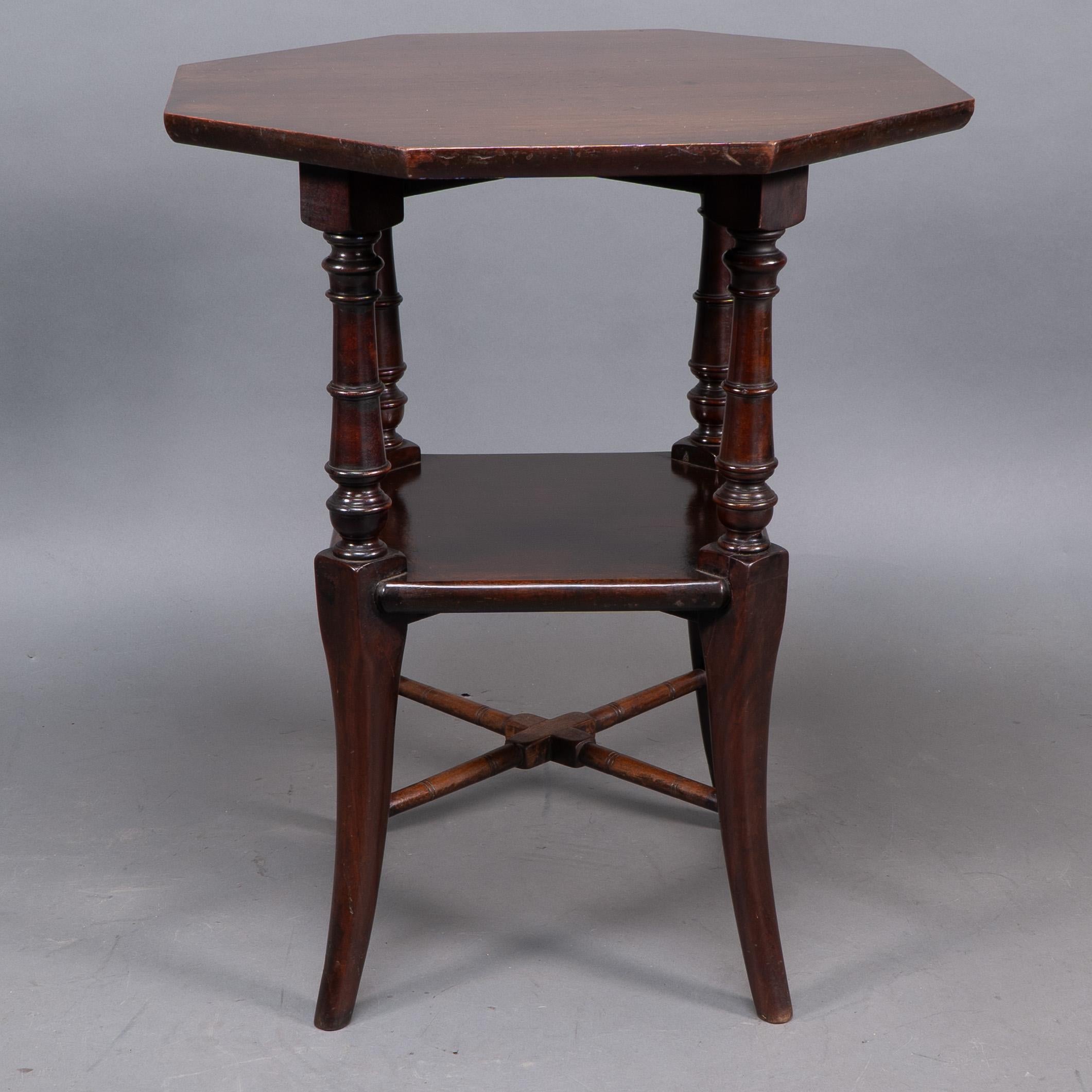 Jas Shoolbred attributed An octagonal Mahogany side table with central shelf, carved circular details to the legs, united by lower cross stretchers.