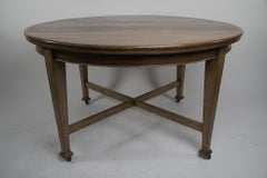 Jas Shoolbred. An Arts & Crafts round oak dining table with square tapering legs
