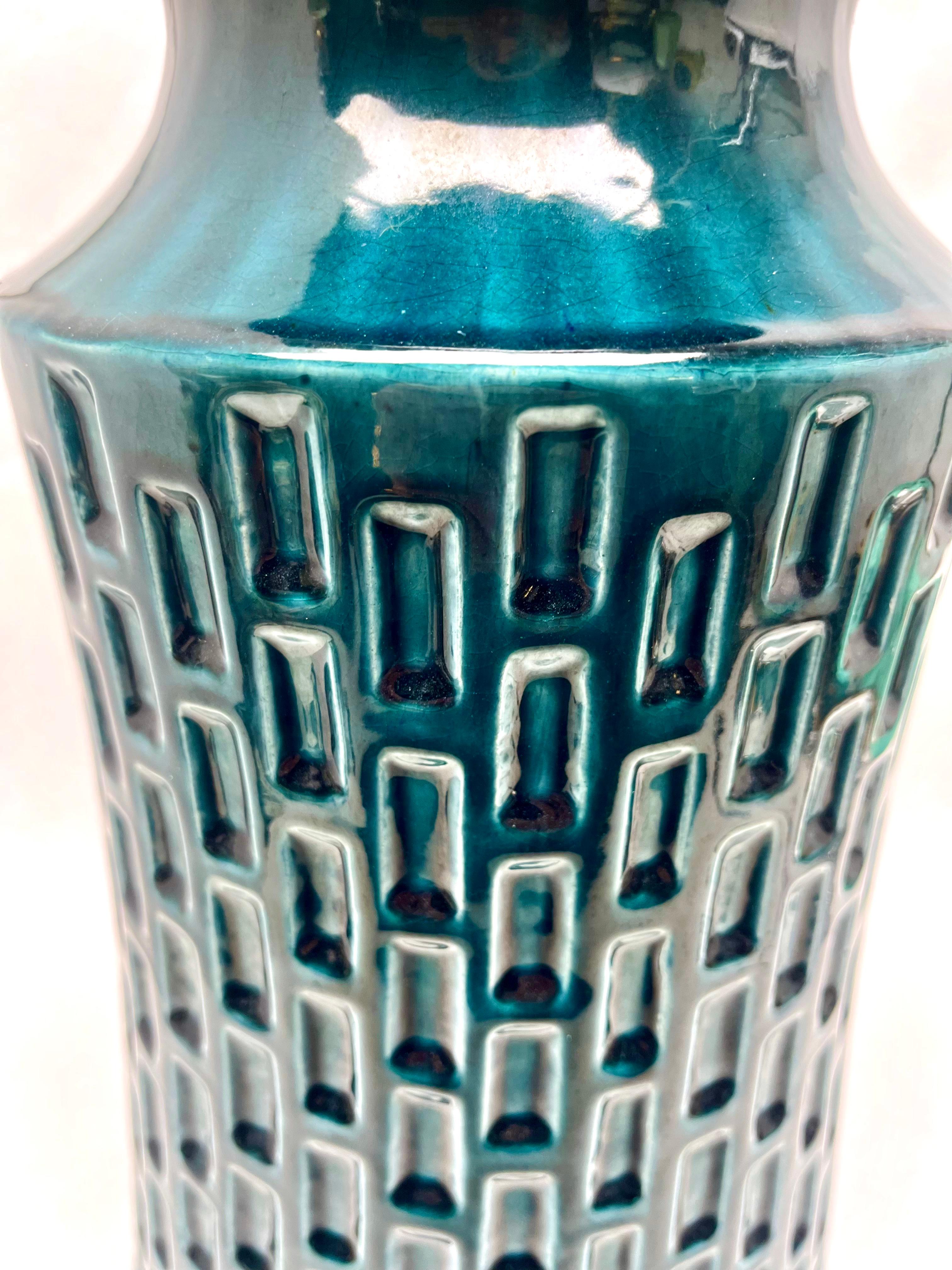 Vase vintage Jasba en glaçure bleue à gouttes, avec un motif en creux.
En regardant de près, la glaçure comprend des mouchetures noires et bleues de mer qui donnent plus de profondeur aux surfaces.

N'hésitez pas à nous contacter pour toute autre