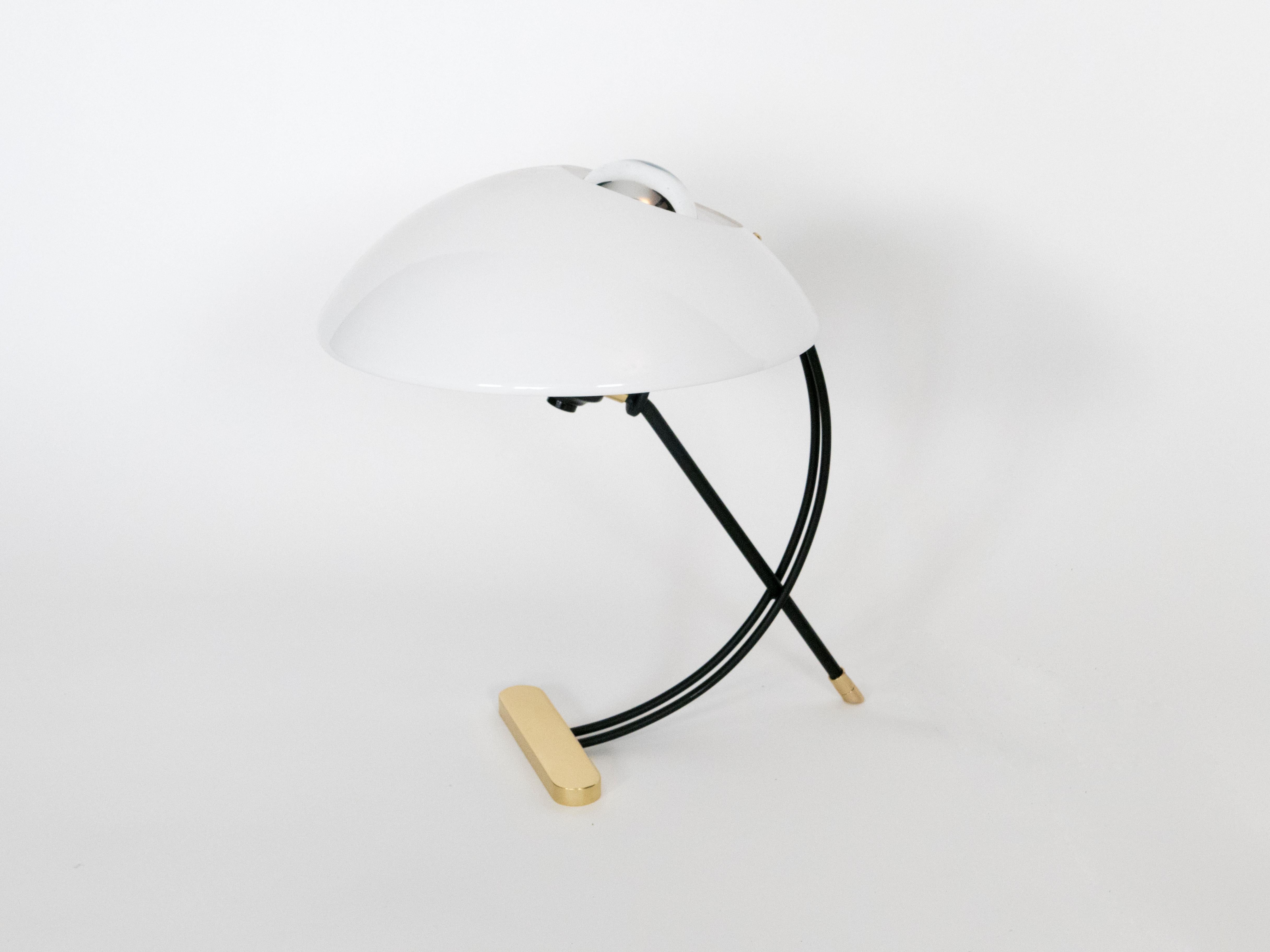 La elegancia de mediados de siglo se une al refinamiento contemporáneo en esta elegante lámpara de sobremesa. Fabricado en latón, acrílico y esmalte negro, encarna los elementos por excelencia de la época, a la vez que desprende un atractivo