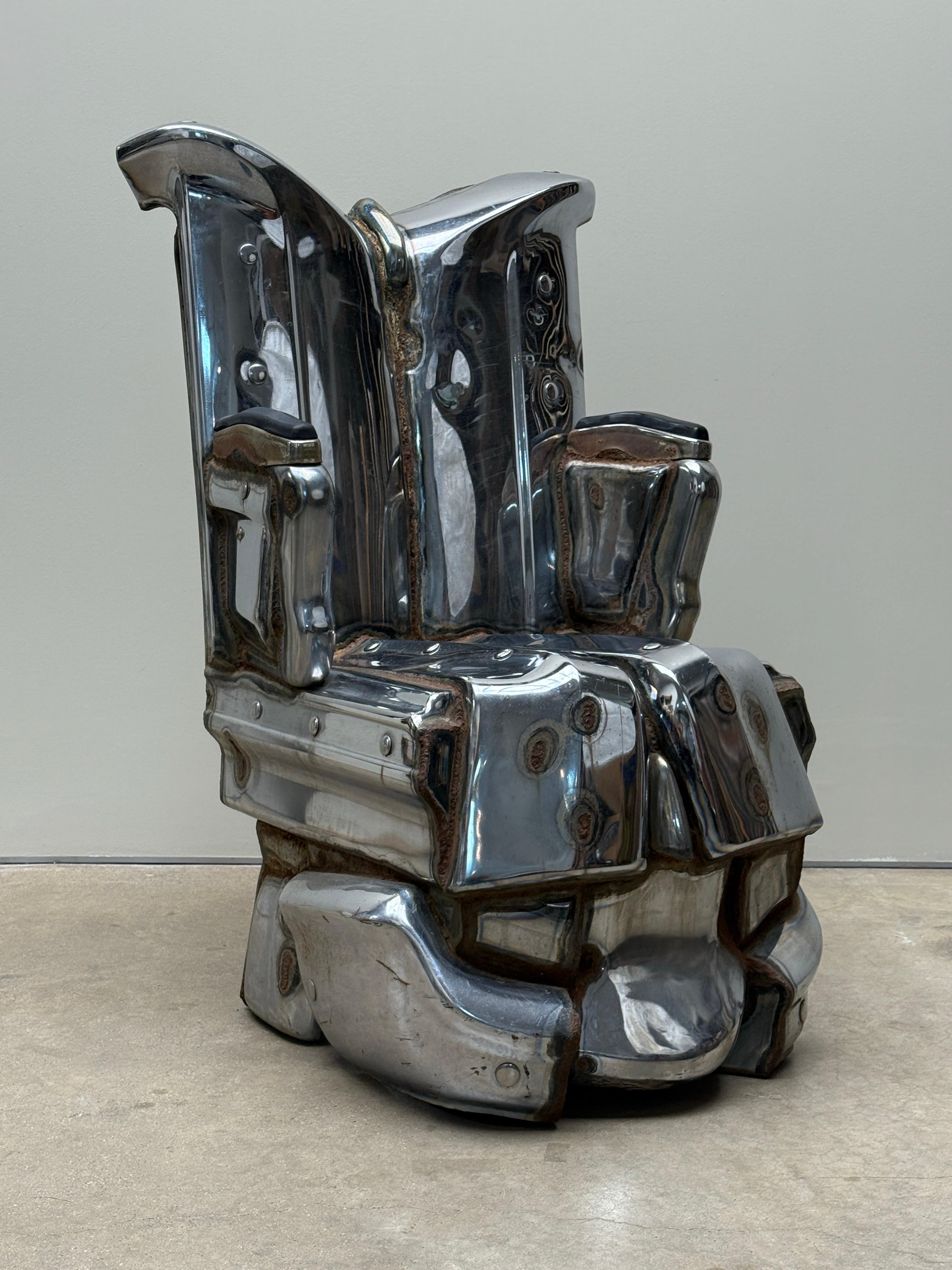 Una silla/escultura única hecha con parachoques de coche por Jason Seley, 1975. 

Seley fue decano de Arquitectura en la Universidad de Cornell y enseñó en la Universidad de Hofstra y en la Universidad de Nueva York. Su obra forma parte de la