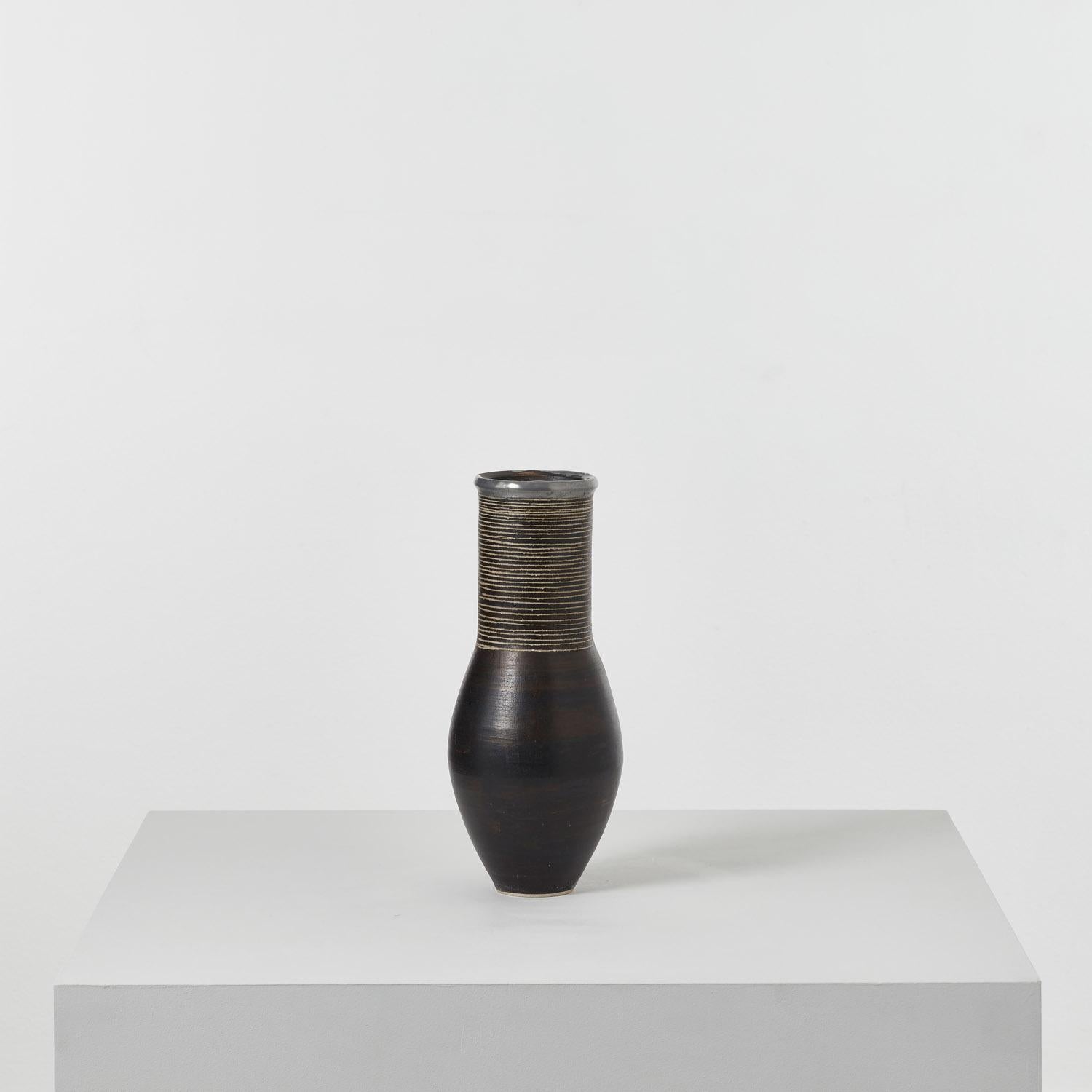Elemental, concise, quiet. A signed ovoid vase by Jason Wason, marked by fine sgraffito bands and a reflective pewter rim. Likely worked from a white clay body with an oxide surface, then incised to expose the clay underneath. 

Jason Wason (b.