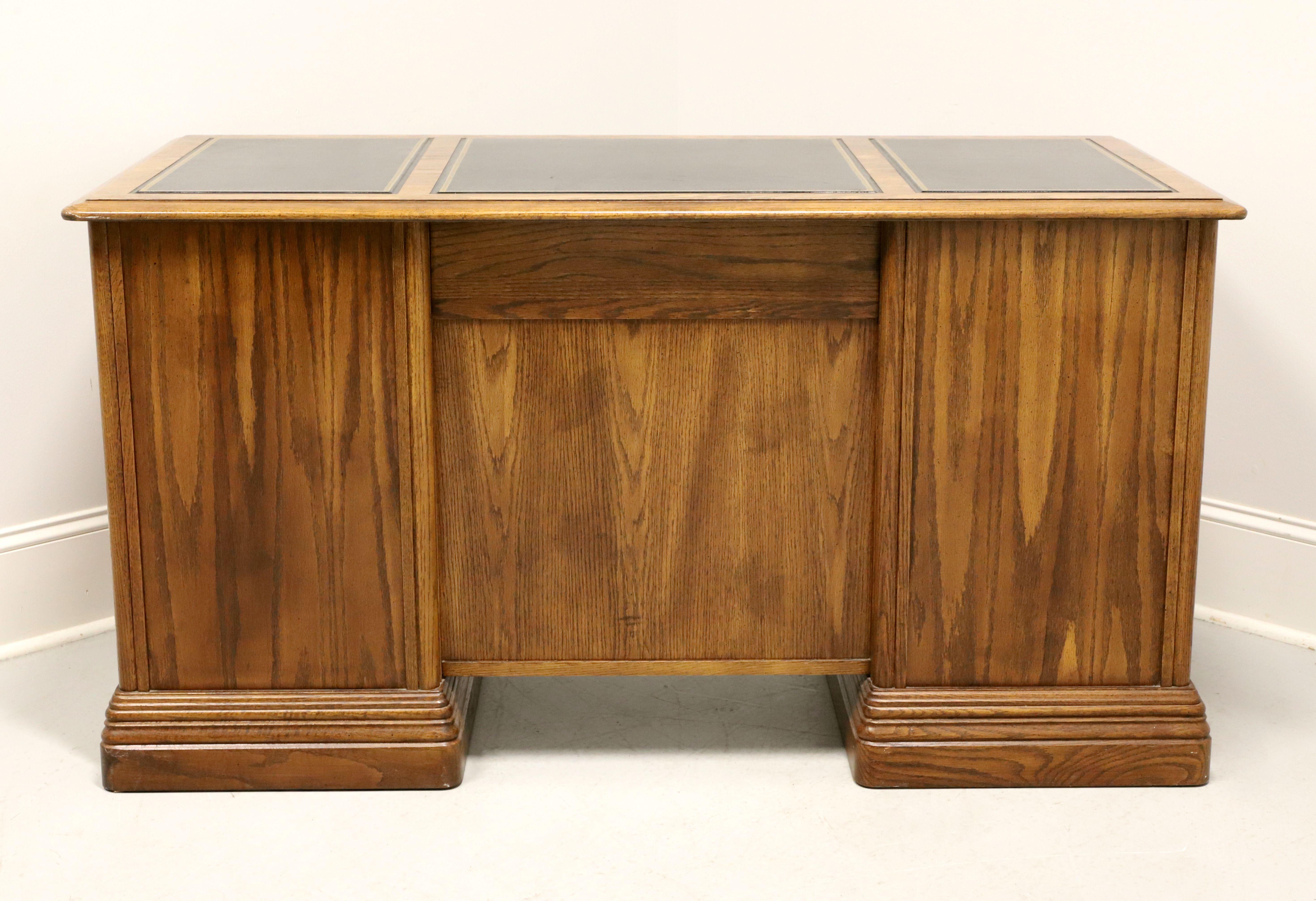 A Traditional style double pedestal executive desk by Jasper Cabinet Company, their Americana. Solid oak, embossed black leather top, brass hardware, and solid base. The user side of the desk features eight drawers of dovetail construction,