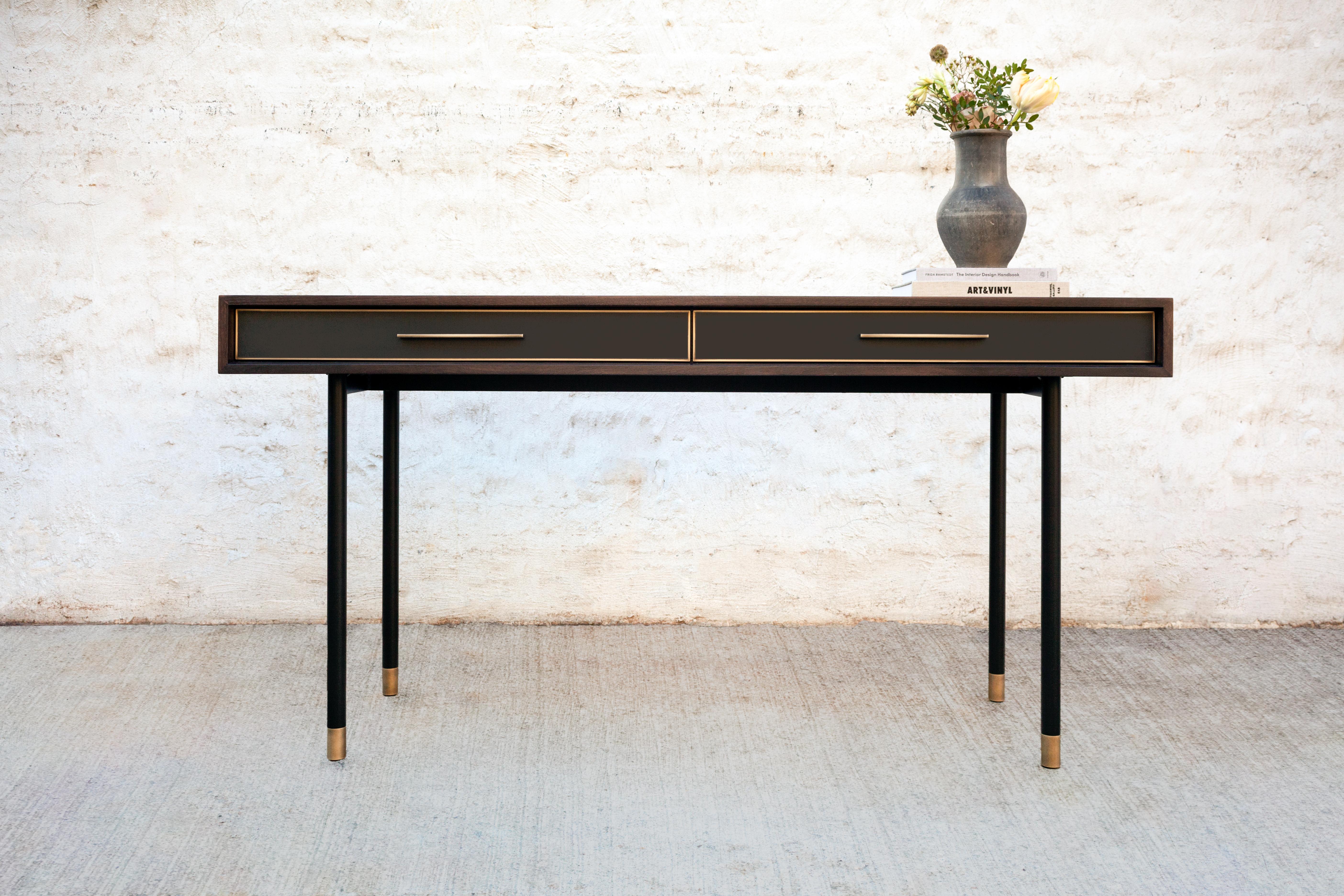 The sleek and striking Jasper console features oxidized walnut, a blackened steel frame and bronze base with adjustable feet, and blackened steel encased in epoxy resin drawers with black leather lining and hand-sculpted bronze pulls.

Dimensions