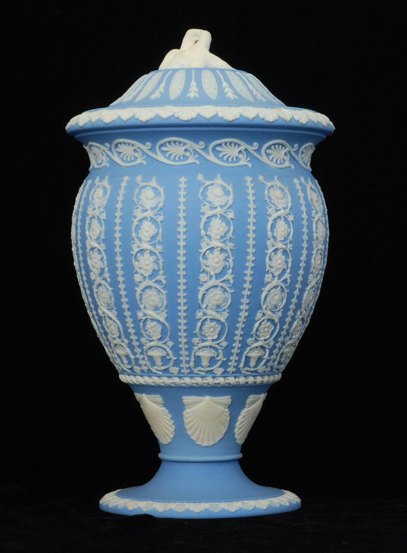 A finely worked vase in solid pale-blue jasper, engine turned and decorated with arabesque designs; the lovebird finial finishes the composition very nicely.