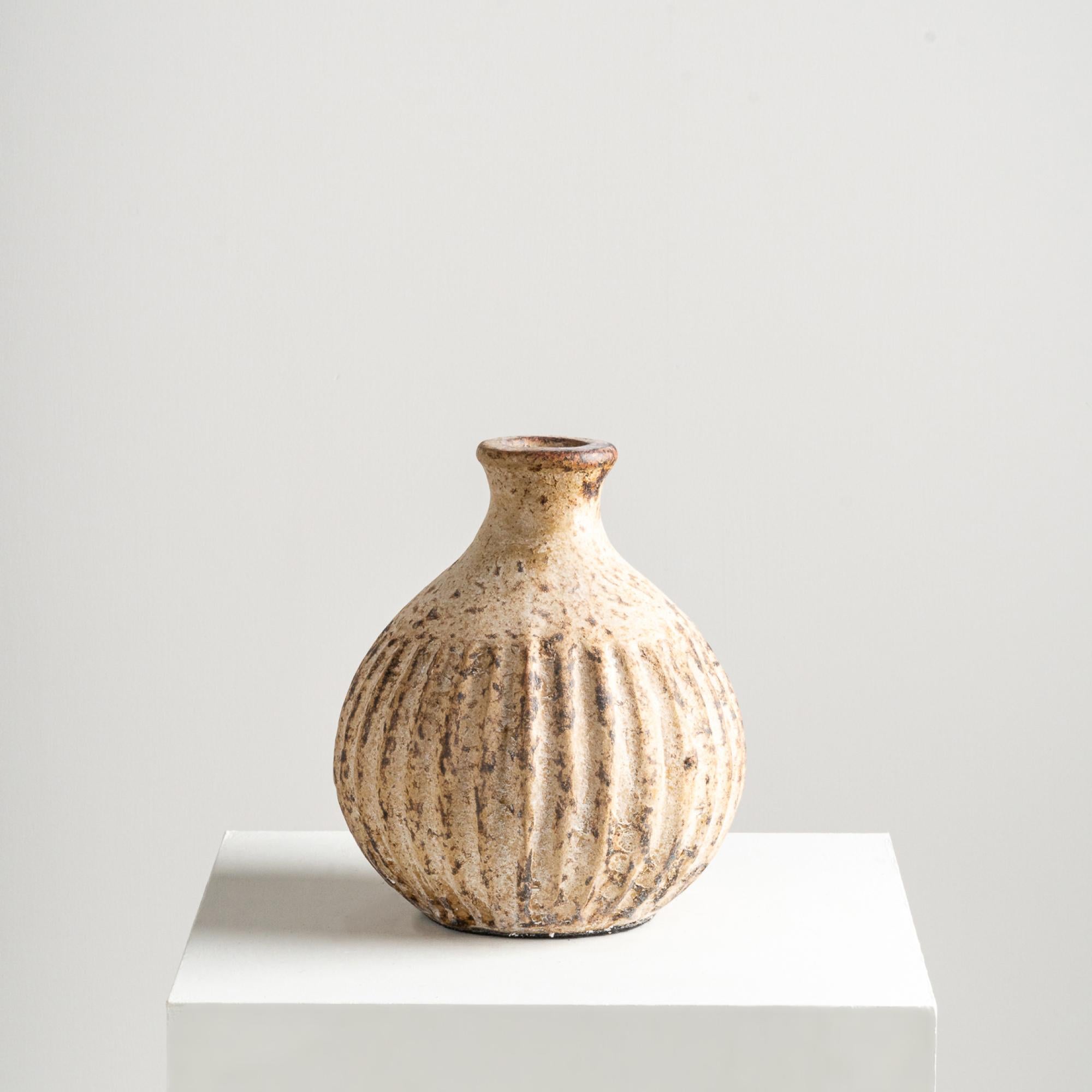 Il vaso Jaurès, con la sua forma a bulbo unica e i suoi dettagli strutturati, valorizza qualsiasi ambiente. Realizzata a mano con argilla di terracotta, la sua finitura e le sue texture infondono un'essenza giocosa ma elegante alla sua presenza