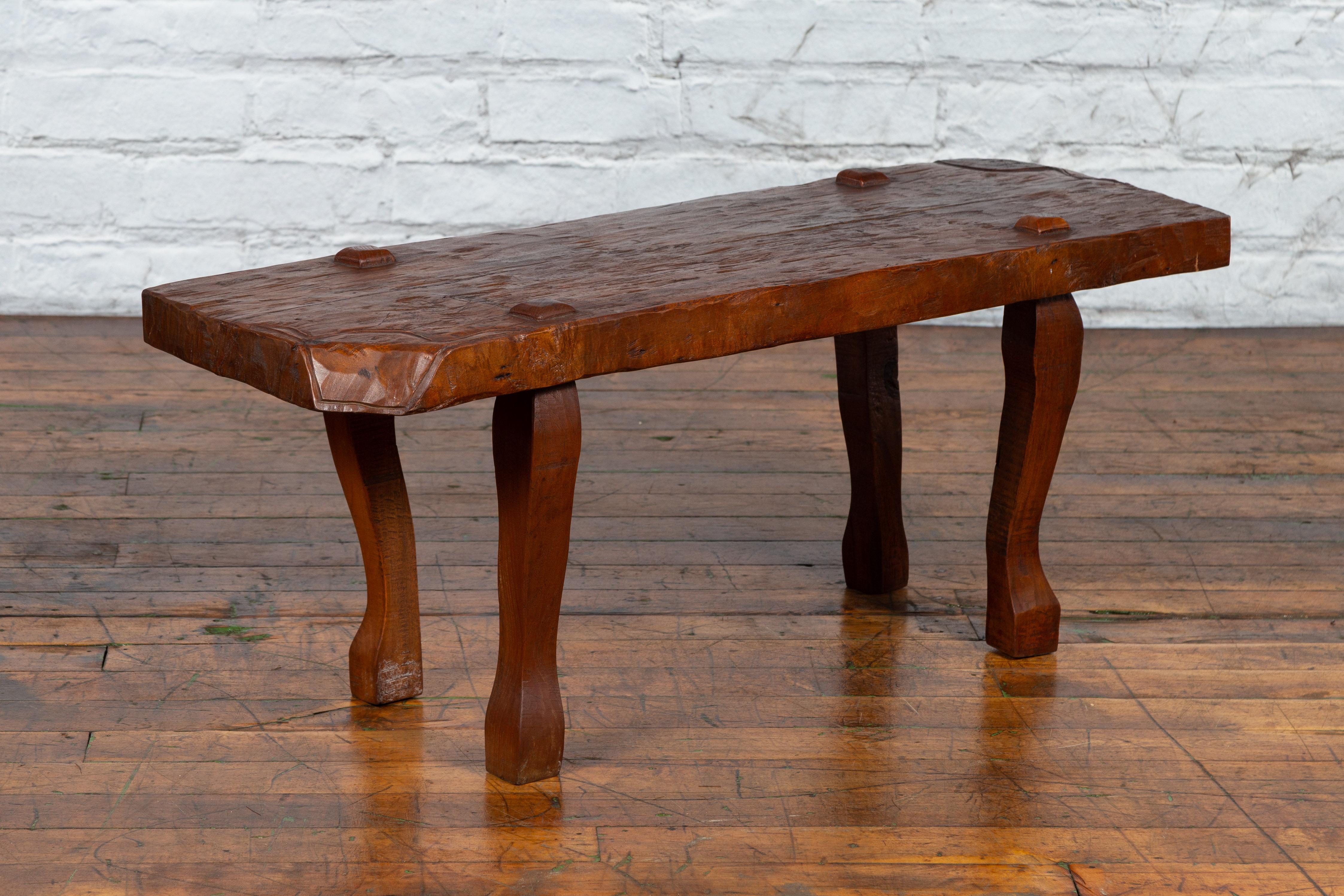 A Javanese Arts & Crafts teak low table / bench from the early 20th century, with carved recessed legs. Created in Java during the early years of the 20th century, this Arts & Crafts teak table features an irregular rectangular top with raised