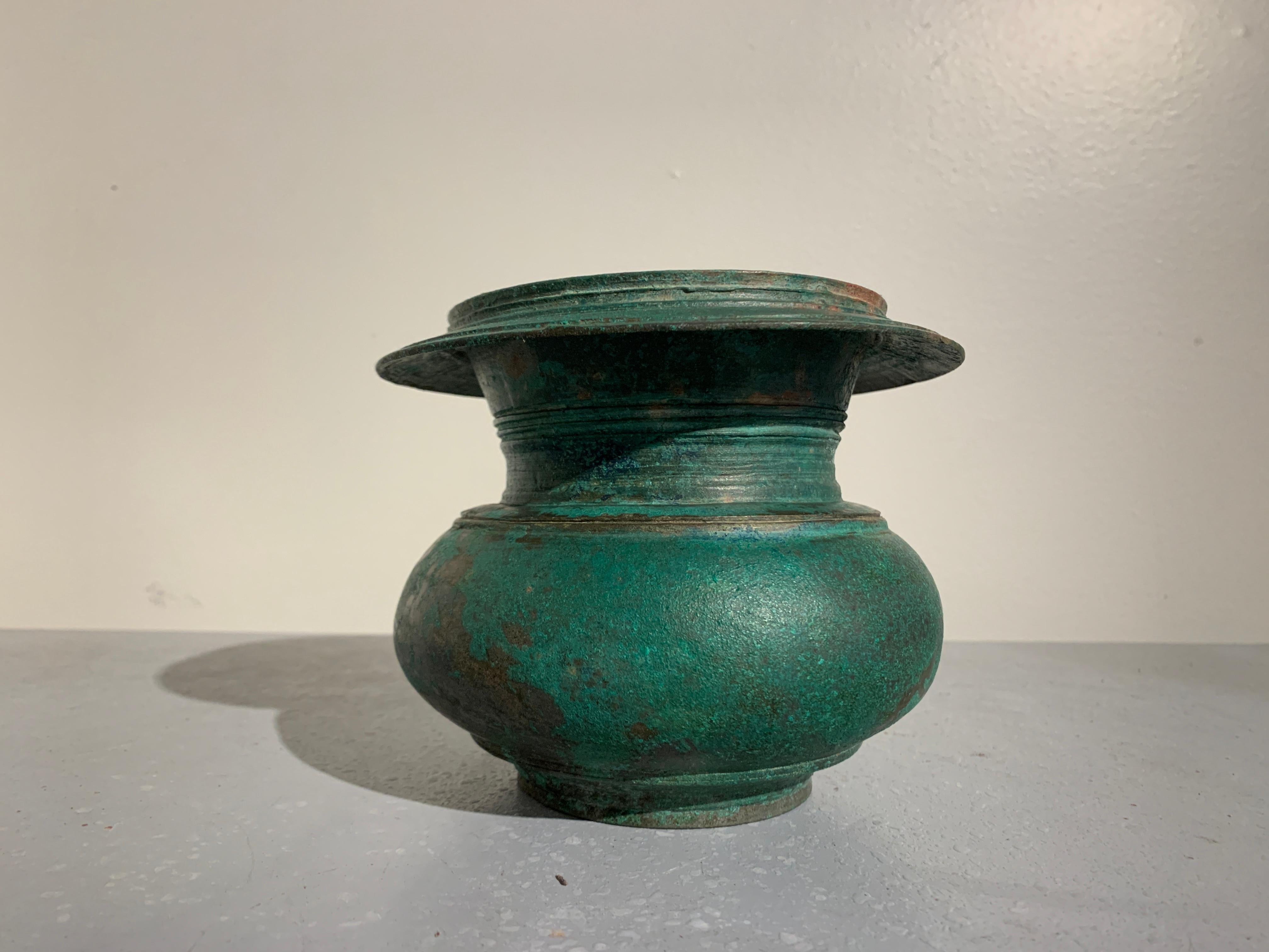 A simple and gorgeous Indonesian bronze ritual water vessel, Central Javanese Period, Java, 13th century.

The vessel of globular form with thick neck and wide, flared mouth. The bronze with a beautiful patina of malachite greens and cuprite reds.