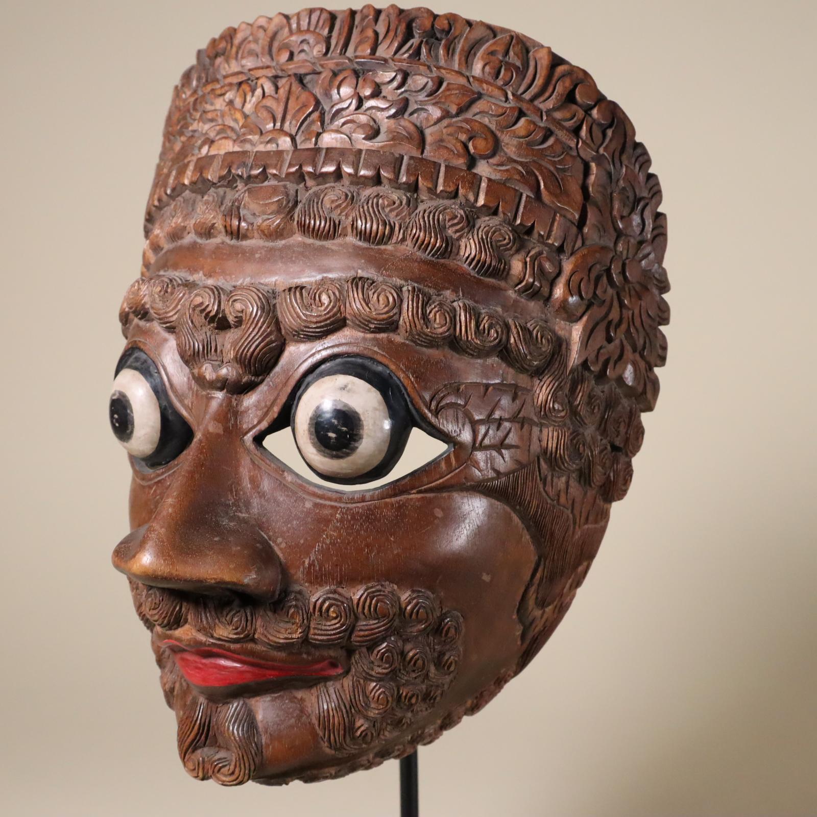 A tour-de-force of carving in chocolate brown hardwood. This is a face mask worn in dances at the royal compound (kraton) in Yogyakarta, Java, Indonesia. The Javanese script on the back is the name of the character, Lembu Amiluhur, the king who is