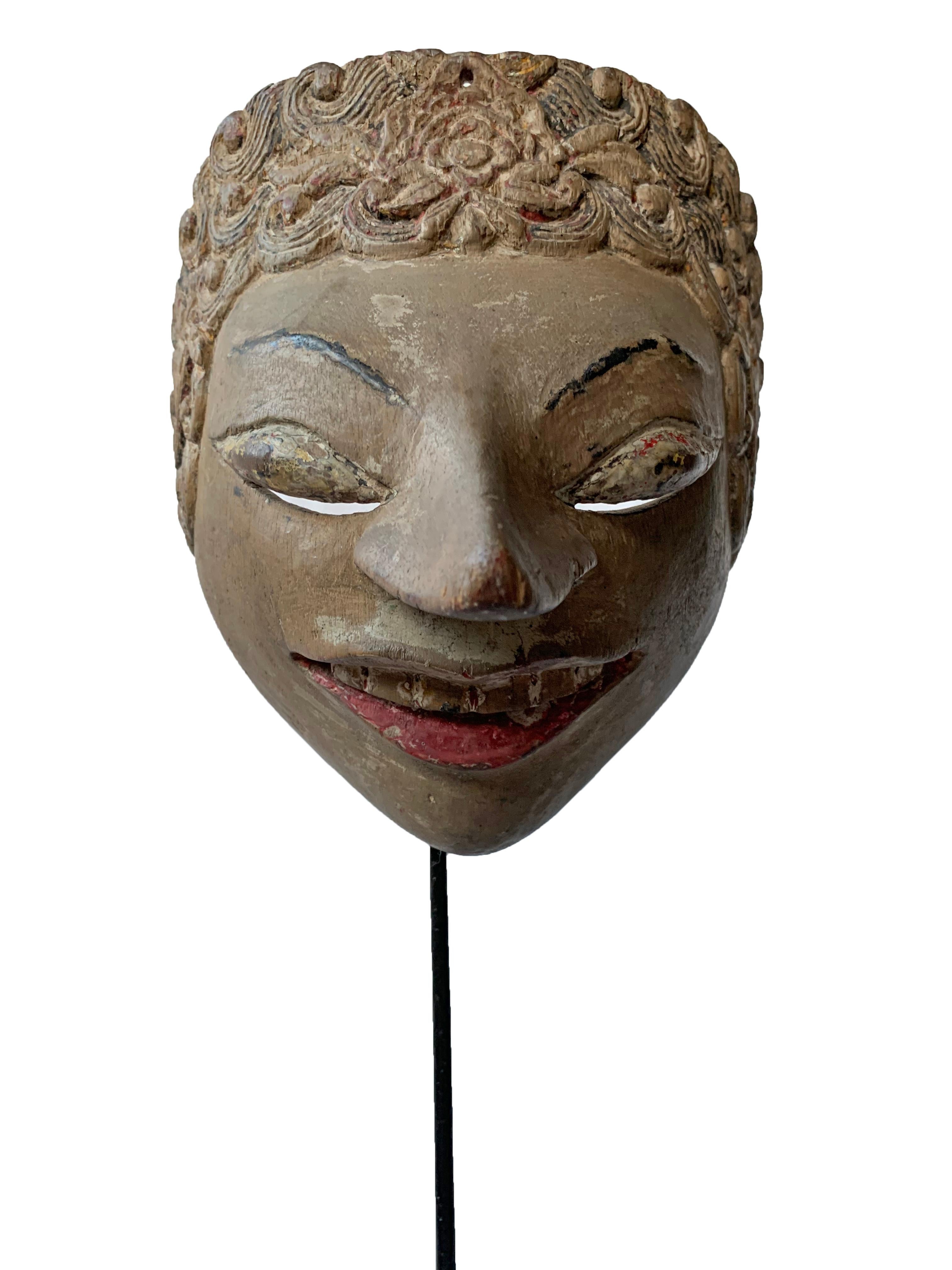 This early 20th century ‘Wayang topeng’ mask was used in Javanese masked dance performances. This mask features a beige and white polychrome finish with hints of original red lips and black pupils that form a dramatic appearance. 

Measures: