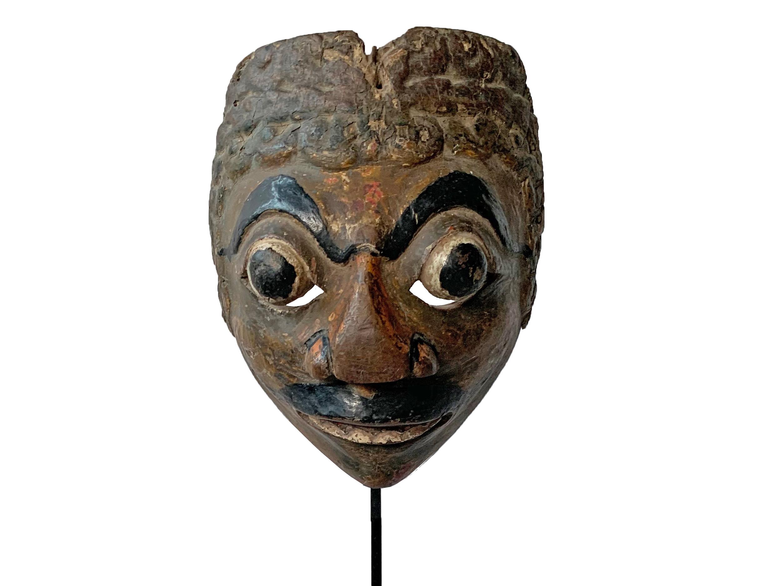 This early 20th century ‘Wayang topeng’ mask was used in Javanese masked dance performances. 

Measures: Height with stand 47cm; Height 18cm x Width 14cm x Depth 8cm.



