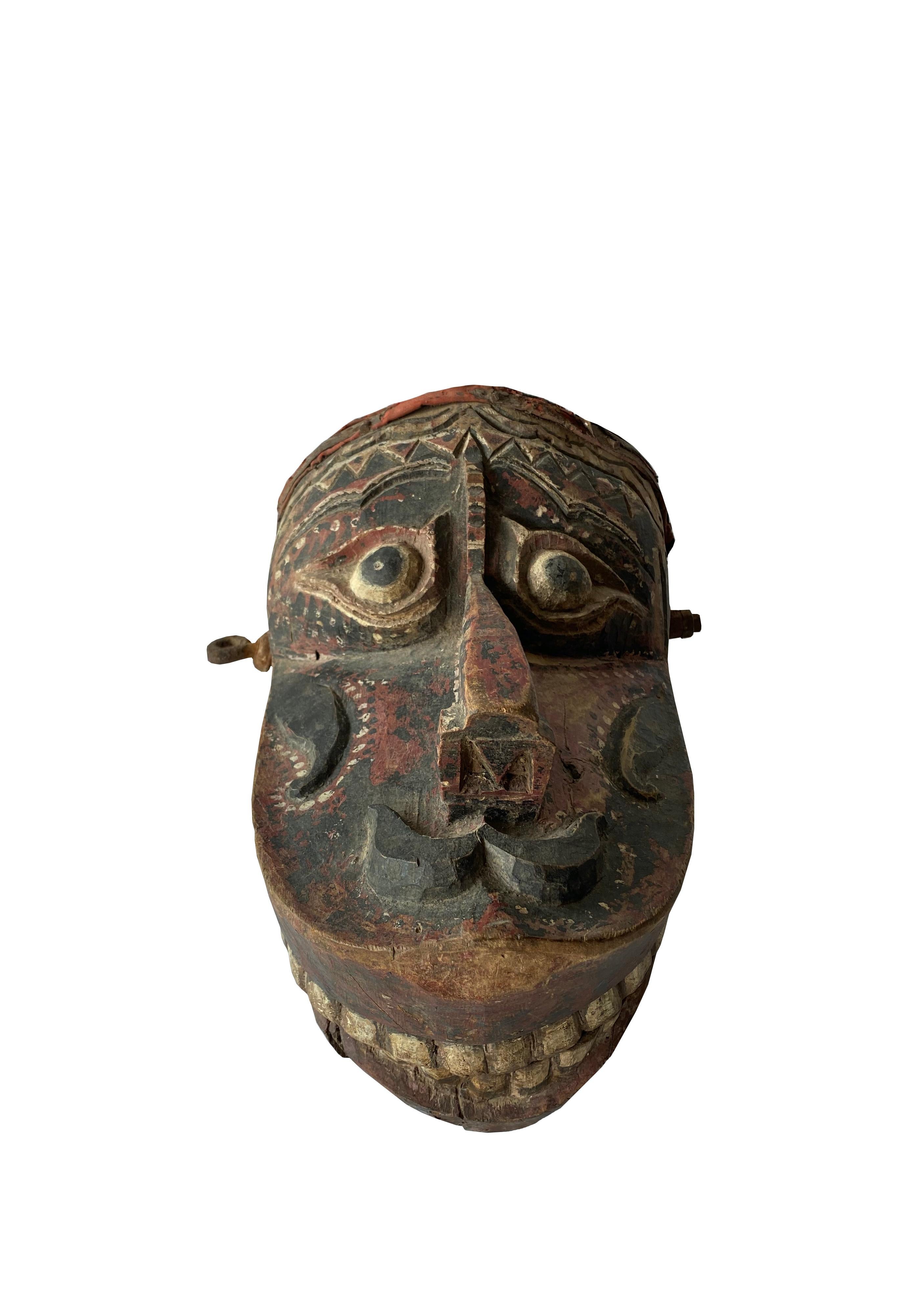 This mask from Java depicts a mythical creature which would have been used in ‘Wayang Topeng’ dance performances. It features handles which are used to open and close the creatures mouth and a mix of white, red and black polychrome. The mask also