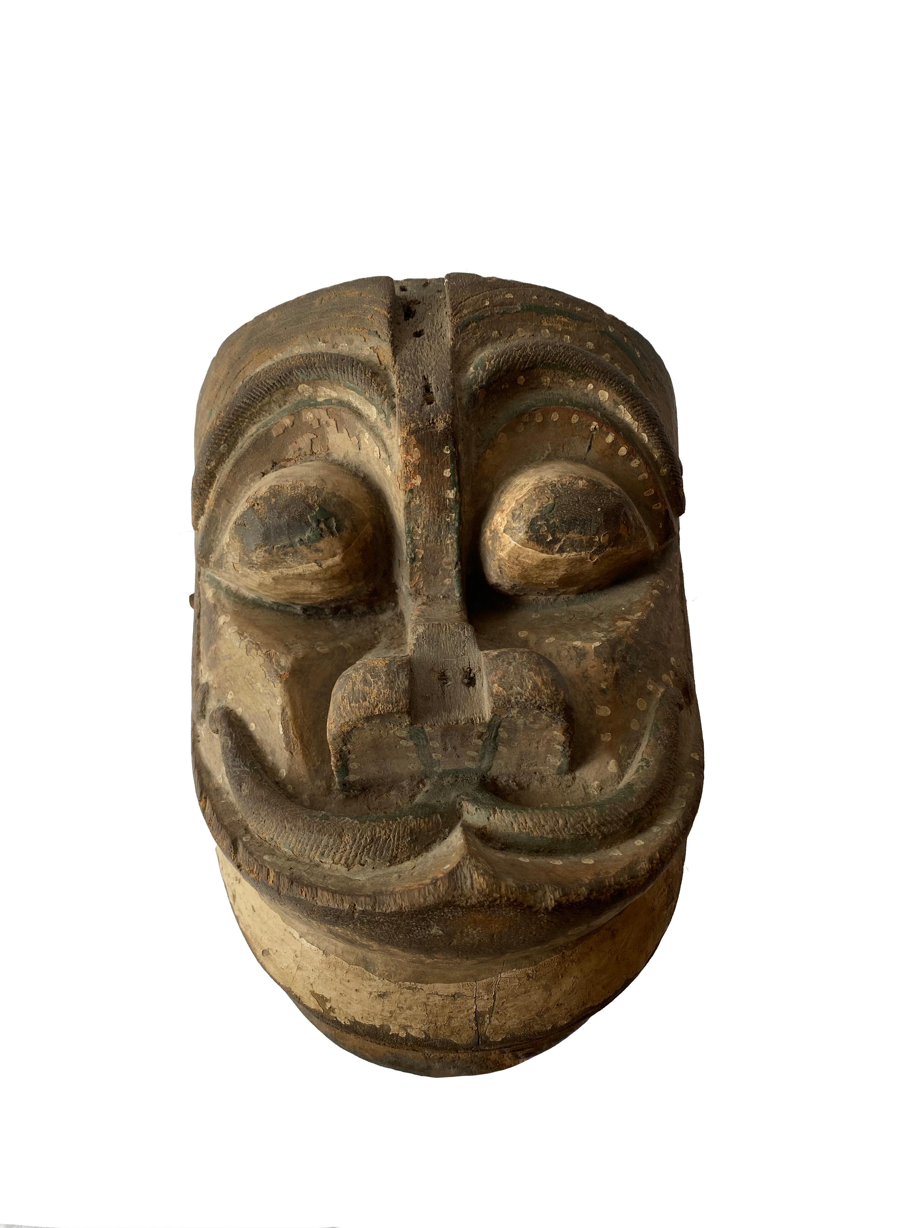 This mask from Java depicts a mythical creature which would have been used in ‘Wayang Topeng’ dance performances. It features handles which are used to open and close the creatures mouth and a mix of white, dark green and black polychrome. 

  