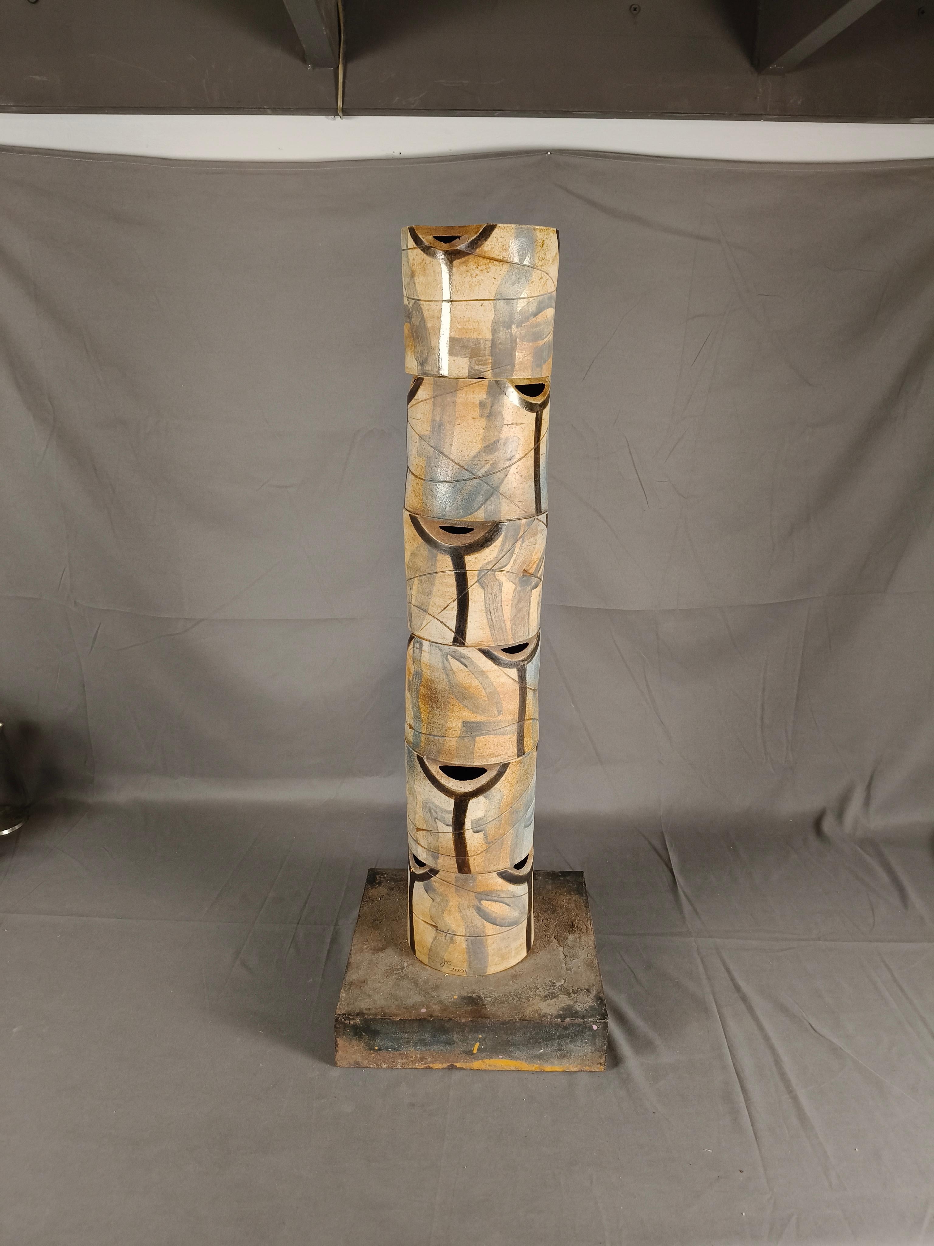 A tall hand-painted high temperature ceramic column sculpture by Mexican artist Javier Cervantes. The column is formed by 6 sections that get piled together over a steel bar attached to a base. The column is hand-painted with organic motifs in