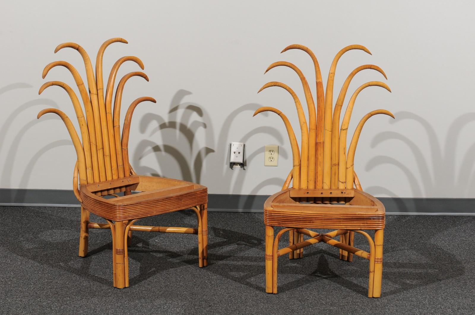An absolutely majestic set of twelve (12) custom made palm frond style dining chairs, circa 1950. Exceptionally conceived and crafted rattan and hardwood construction with a magnificent back detail. Stout, rigid and comfortable - built for heavy