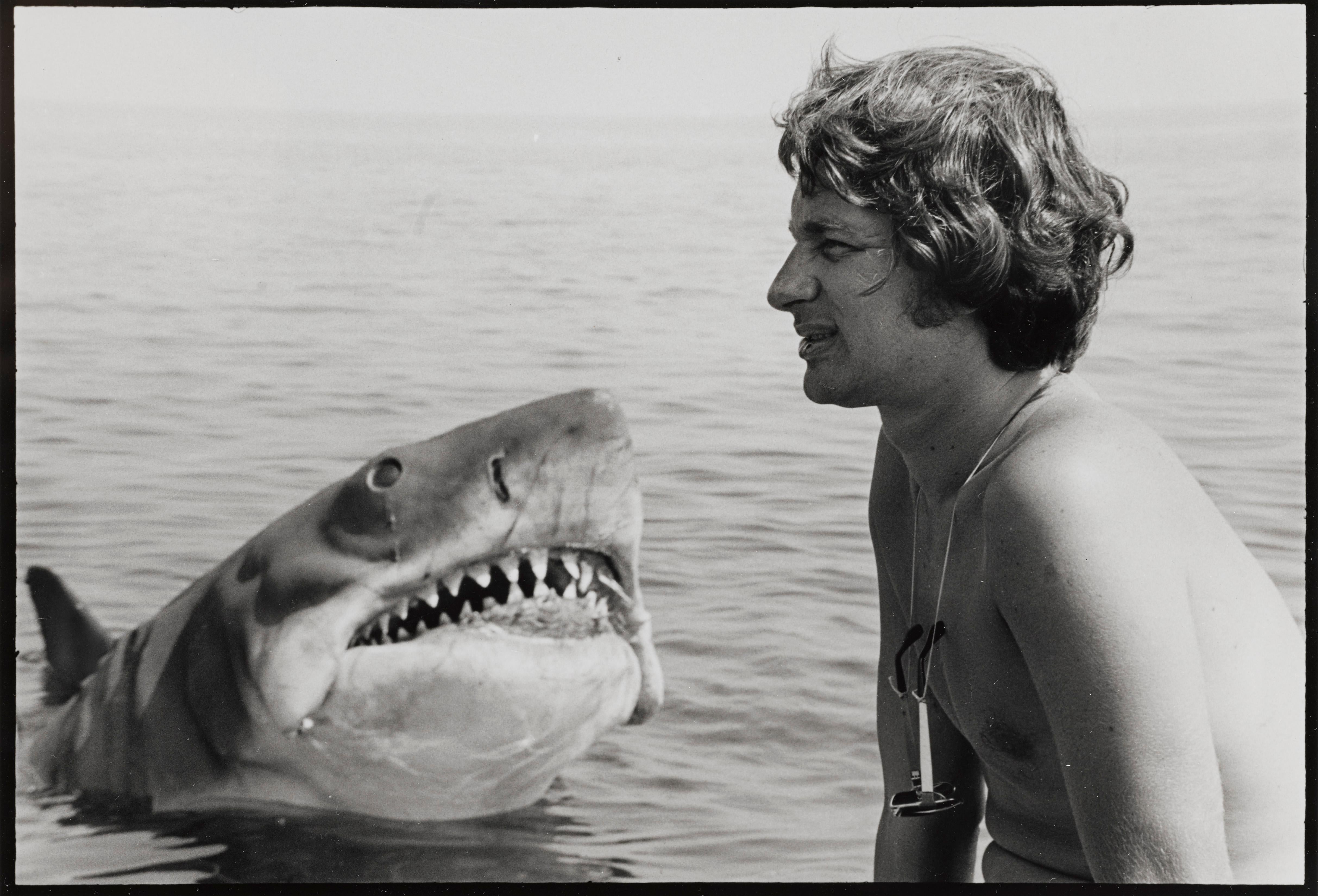 Jaws (1975) this is a deluxe hand printed candid file photo showing Spielberg squatting by Bruce the shark.
This photographs was taken during rehearsals.
    