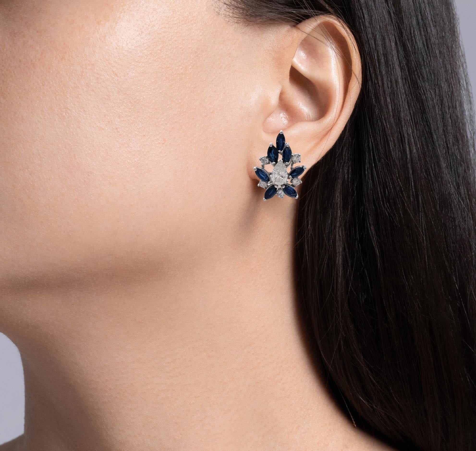 Jay Feder 14k White Gold Blue Sapphire and Diamond Earrings

There are 2 large pear shaped diamonds in the center; total carat weight is 1.36ctw.

Set with 14 marquise shaped blue sapphires; total weight is 5.0 carats. Total weight of small round