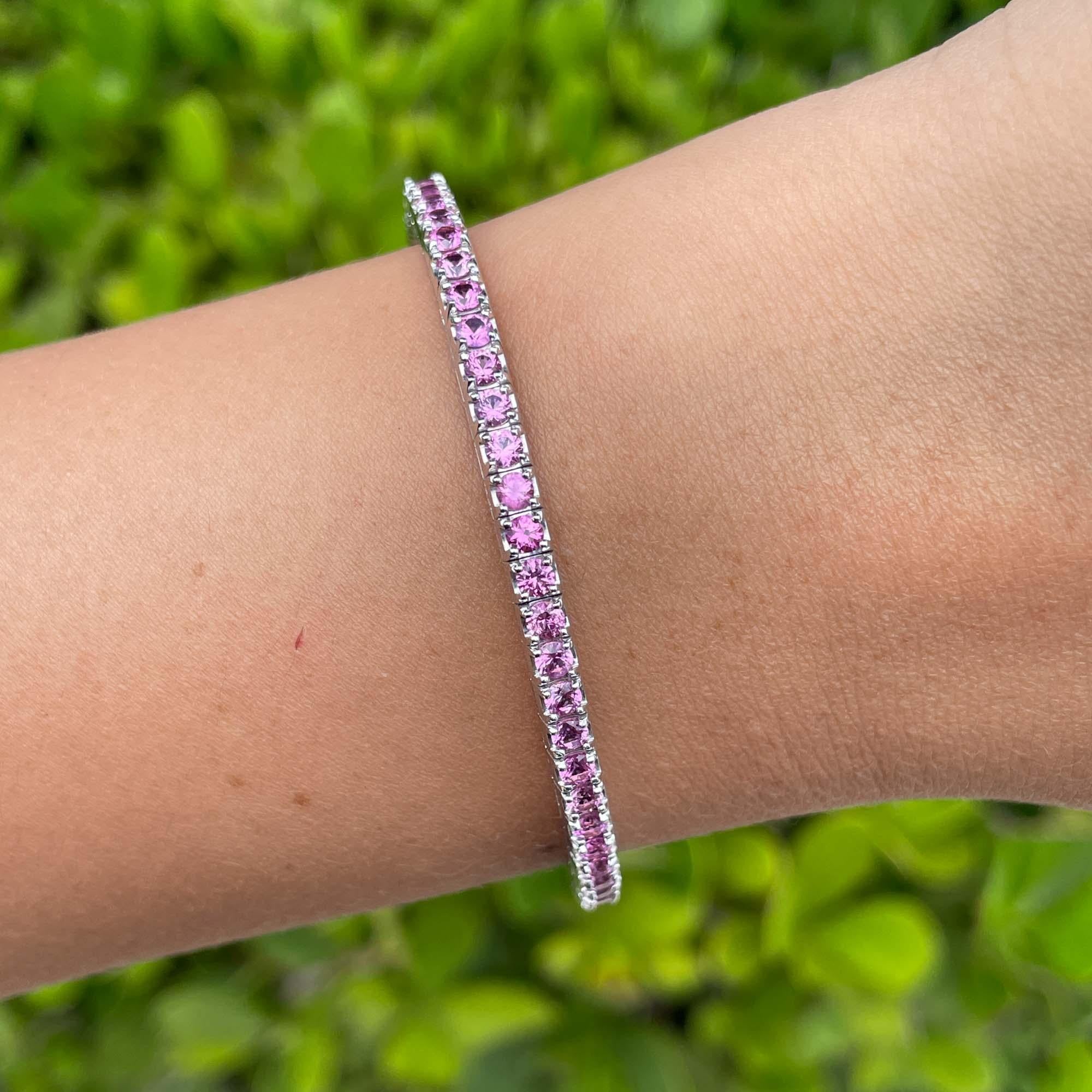 Jay Feder 14k White Gold Pink Sapphire Stretch Tennis BangleBracelet

Set with 63 round pink sapphires; total carat weight is 5.51ctw.

The bracelet is 2.5 inches in diameter and 3.30mm wide. Total weight is 14.7 grams.

Please view our photos and