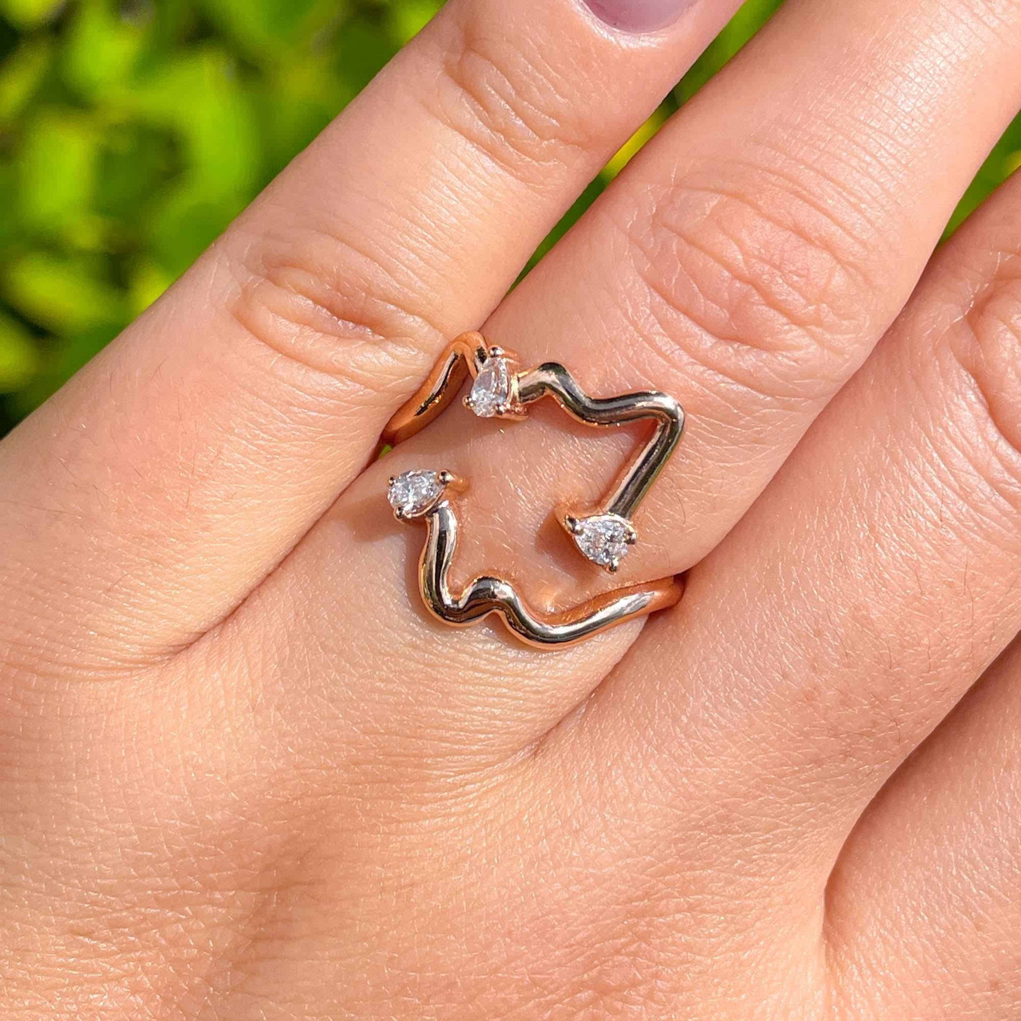Jay Feder, anello da cocktail con diamante a forma libera in oro rosa 18 carati

Con diamanti a forma di pera incastonati; il peso totale è di 0,23 carati. 

Le misure dei piani sono 17,66x18,58 mm. La fascia si assottiglia da 1,74 mm a 1,72 mm