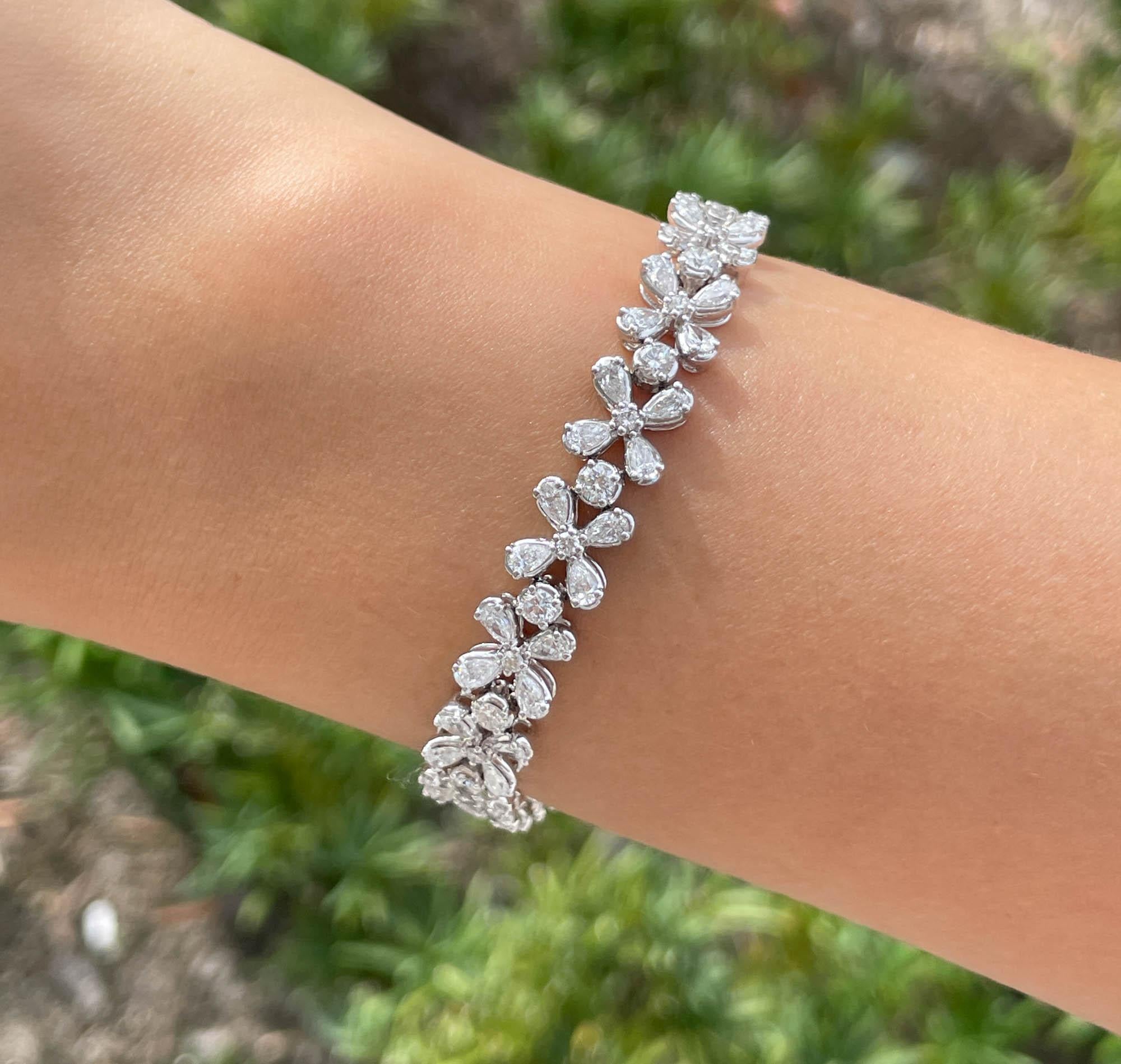 Jay Feder 18k White Gold Diamond Cluster Floral Motif Tennis Bracelet
There are 68 pear shaped diamonds, total weight is 4.61 carats; and 34 round brilliant diamonds; total weight is 2.00 carats. 
The bracelet is 7 inches long and 8.62mm wide.
Total