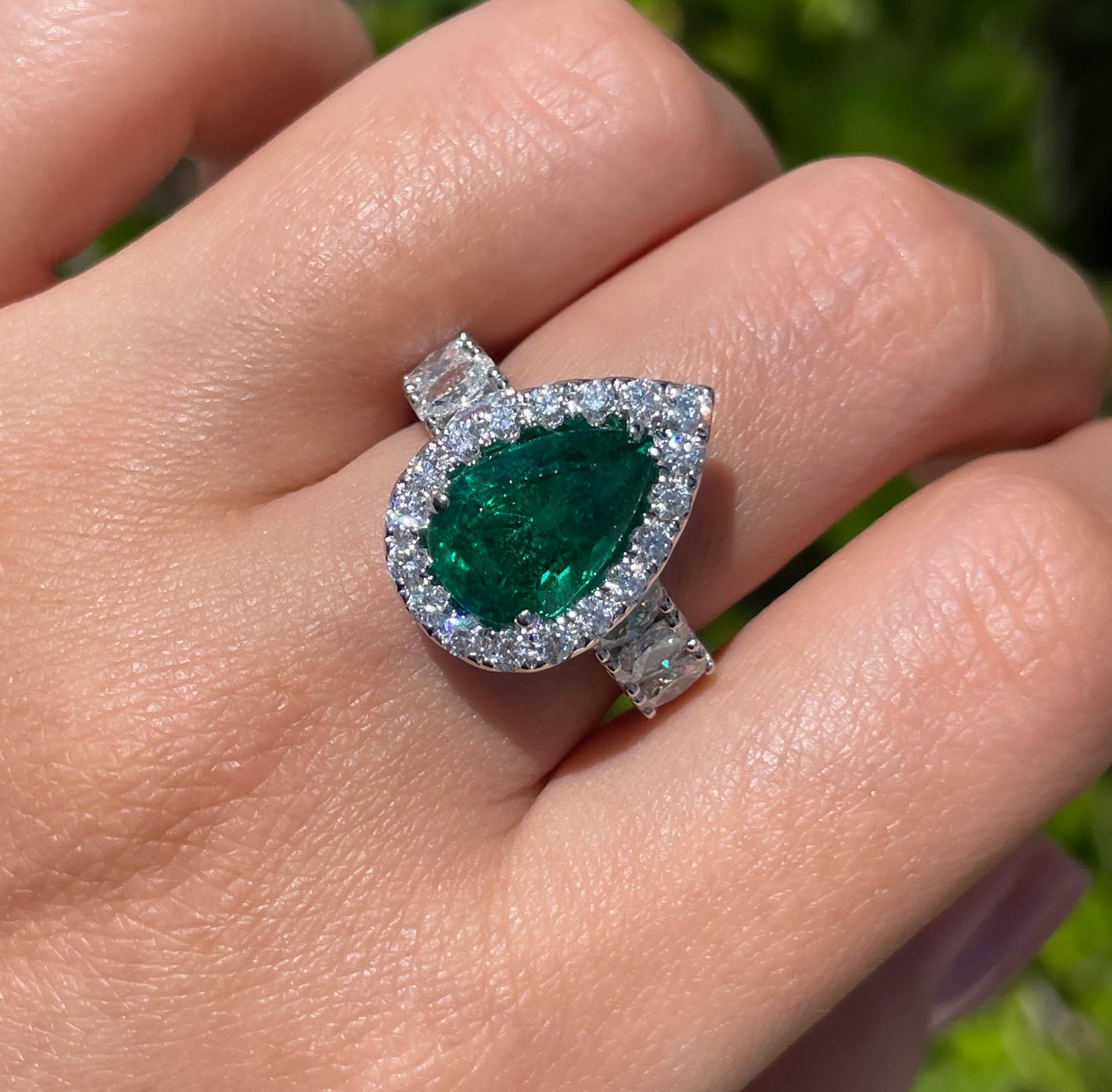 Classic 18k White Gold Green Emerald and Diamond Engagement Right Hand Ring 
The center stone is Natural Pear Shaped Green Emerald; total weight is 3.52ct.
It is set with 6 large oval shaped side diamonds on the band; estimated weight is 1.26ctw.
