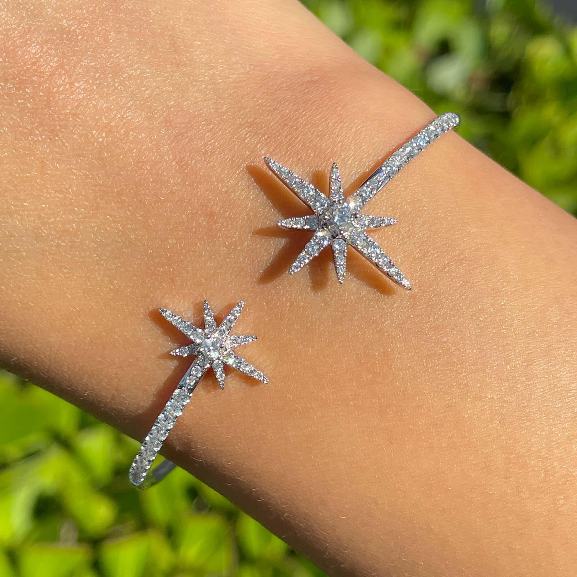 Pulsera brazalete cruzada estrella diamante redondo de oro blanco de 18k Jay Feder

Engastado con 74 diamantes redondos; el peso total en quilates es de 1,2 quilates.

Las estrellas miden 14,43 mm y 21,42 mm de largo. La pulsera mide 5 cm de