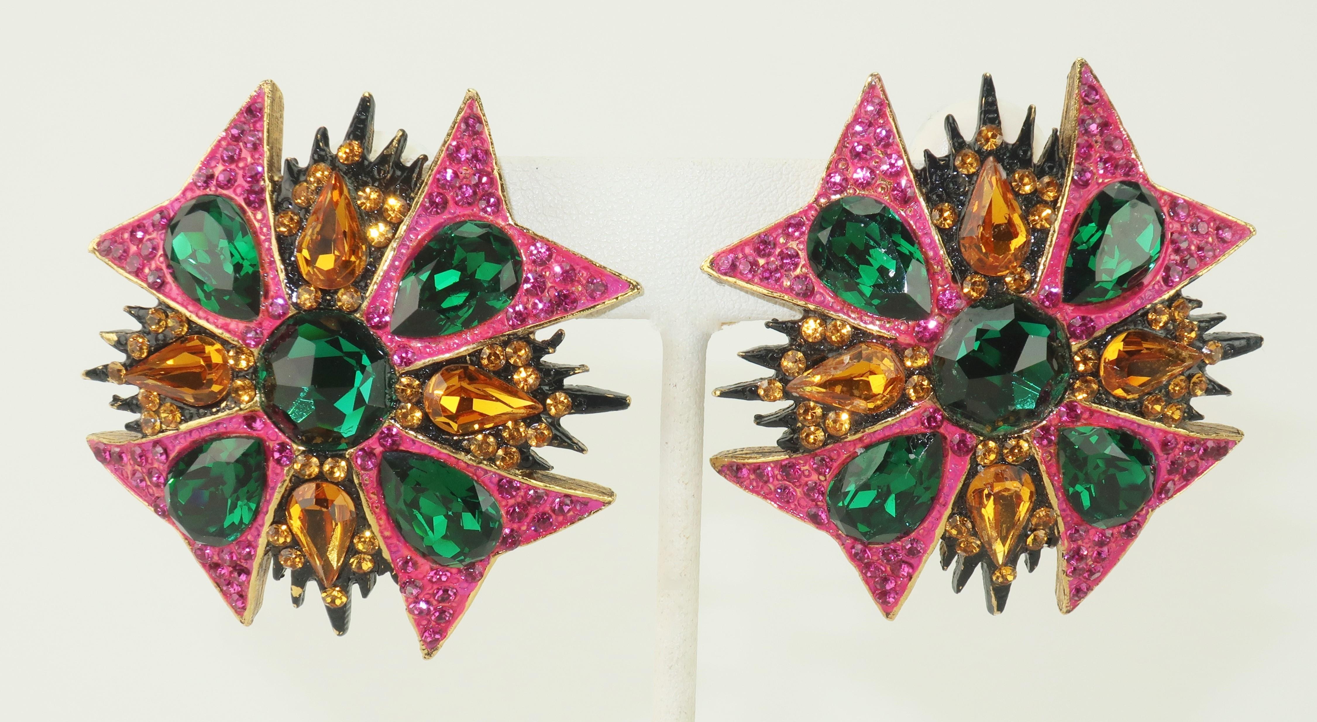 1980’s Jay Feinberg clip on earrings in a Maltese Cross inspired shape with emerald green, amber and hot pink crystal rhinestones set in an antiqued gold tone metal accented with black and hot pink enameling.  Both earrings are signed at the back