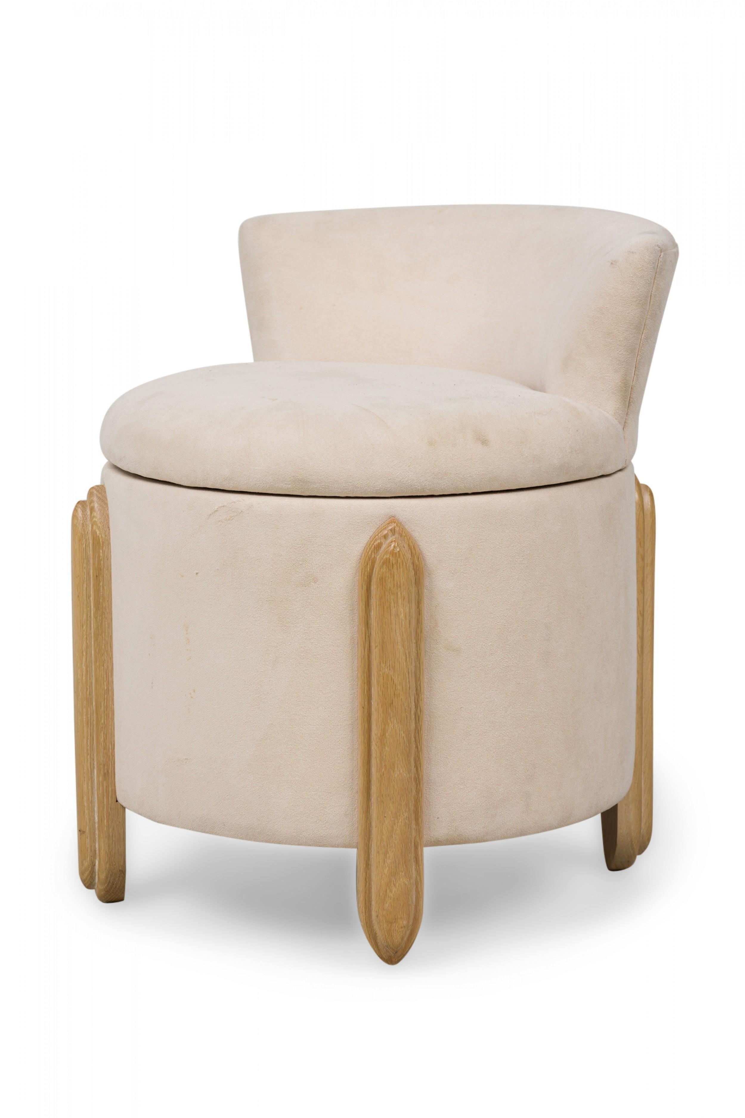 Midcentury American (1970s) barrel form ottoman with low backrest, upholstered in beige suede, featuring oval shaped, beveled legs extending up the sides. (Jay Spectre).
